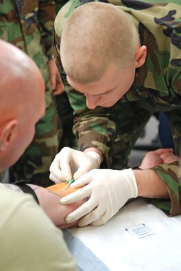 FAIRCHILD AIR FORCE BASE, Wash. -- Senior Airman Tyler Harrington, a 22nd Training Squadron SERE specialist, practices the insertion of intravenous fluids into the arm of Army Staff Sgt. Patrick Kling, a drill sergeant and Combat Lifesaver course instructor. (U.S. Air Force photo/Airman 1st Class Kali L. Gradishar)