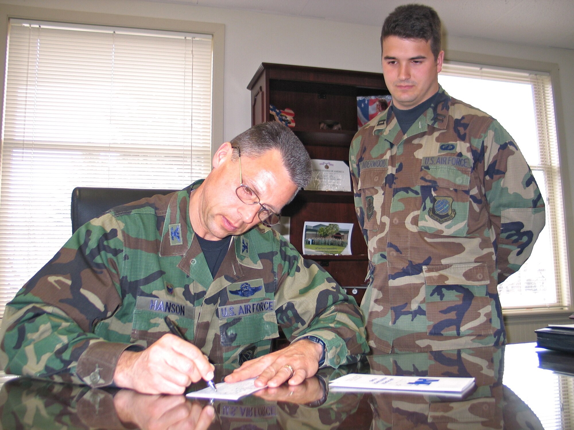 FAIRCHILD AIR FORCE BASE, Wash. -- Col.Scott Hanson, 92nd Air Refueling Wing commander, signs an Air Force Assistance Fund contribution form with the assistance of Fairchild’s AFAF coordinator, Capt. Chris Underwood, 92nd Comptroller Squadron. The AFAF campaign, which started March 12 and will run through April 20, raises money for charities that provide support for Air Force personnel in need. (U.S. Air Force photo/Staff Sgt. Connie L. Bias)
