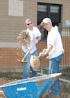 Staff Sgt. Randy Hudson, left, and Tech. Sgt. Craig Cannon, both from the 33rd Information Operations Squadron, get an upper body workout while volunteering March 12 at the Lackland Elementary School on Lackland Air Force Base, Texas. They were among some 20 volunteers from Security Hill who worked four-hour shifts building a habitat for the school. The habitat includes a pond and sidewalk. (USAF photo by Alan Boedeker)                               
