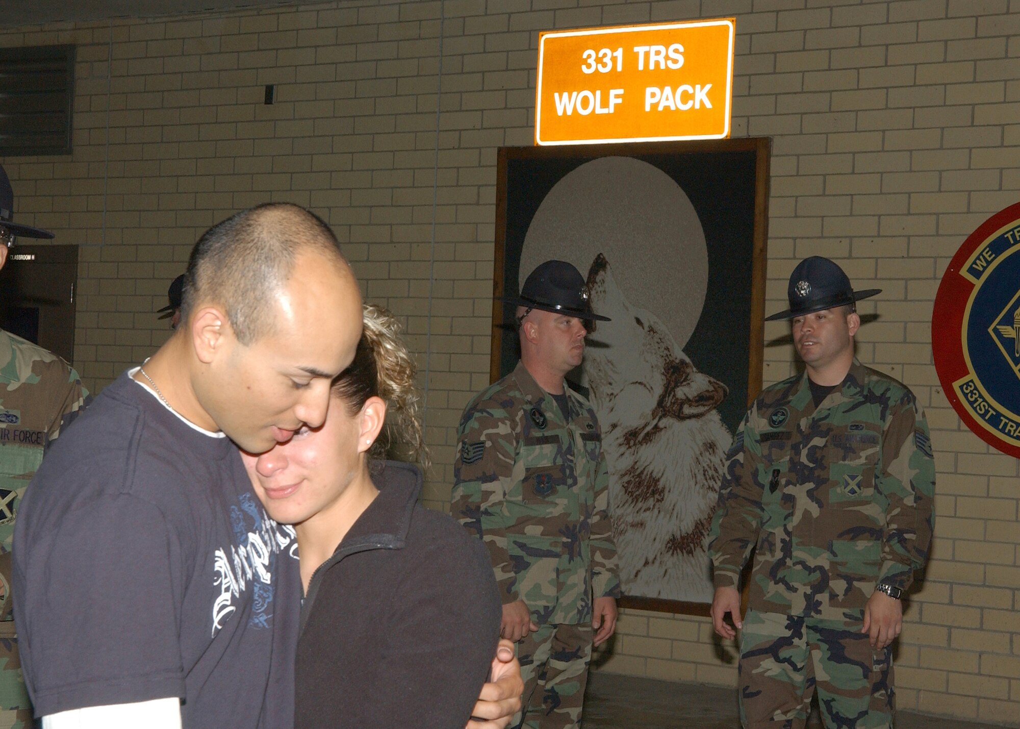 Staff Sgt. Alejandro Huerta shares a tender moment with his girlfriend, Carmen DeLeon Acosta, at the 331st Training Squadron Wolf Pack during a goodbye gathering for military training leaders. He and five other Team Lackland MTIs are on their way to Iraq where they will be training jundis for the next 179 days. (USAF photo by Alan Boedeker)                                