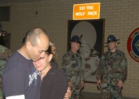 Staff Sgt. Alejandro Huerta shares a tender moment with his girlfriend, Carmen DeLeon Acosta, at the 331st Training Squadron Wolf Pack during a goodbye gathering for military training leaders. He and five other Team Lackland MTIs are on their way to Iraq where they will be training jundis for the next 179 days. (USAF photo by Alan Boedeker)                                