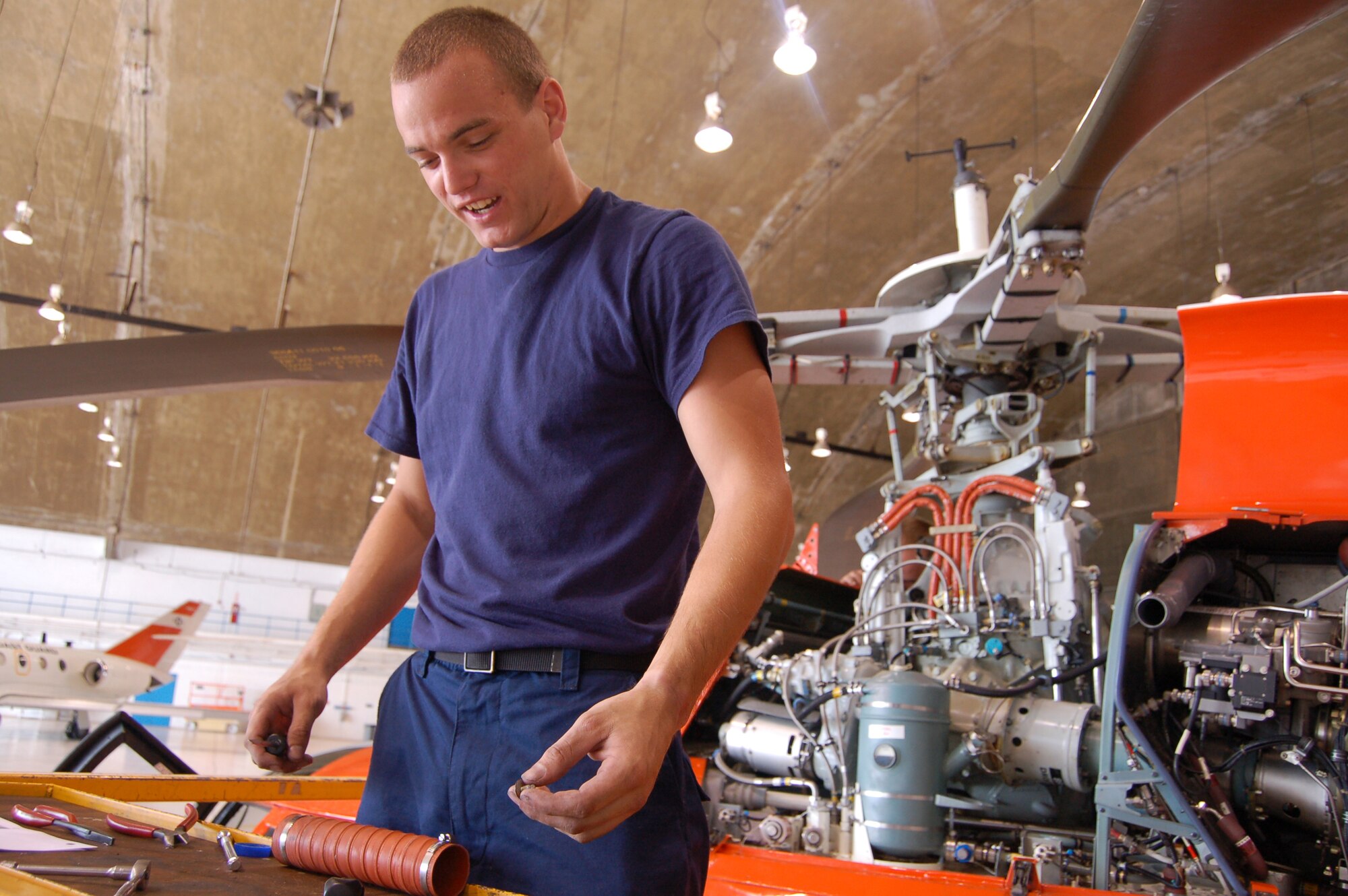 Coast Guard Petty Officer 3rd Class Ryan Harper prepares to replace oil cooler brackets on an HH-65C Dolphin helicopter March 20 at Coast Guard Air Station Borinquen, Puerto Rico. Petty Officer Harper is an aircraft maintenance technician. The Coast Guard air station has four HH-65Cs and 100 Coast Guardsmen. (U.S. Air Force photo/Tech. Sgt. Ben Gonzales)