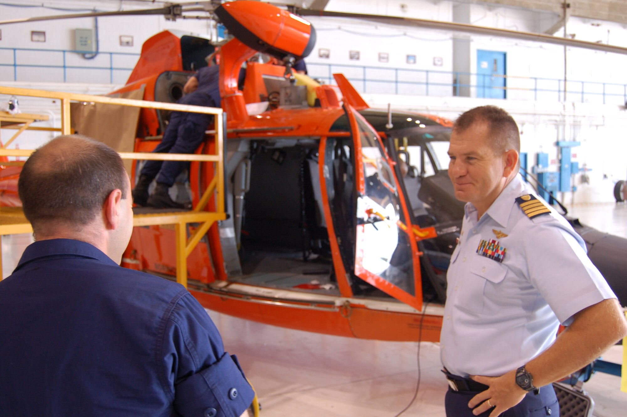 Coast Guard Capt. Thomas Wade talks to a Coast Guard maintainer working on an HH-65C Dolphin helicopter March 20 at Coast Guard Air Station Borinquen, Puerto Rico. Captain Thomas is the commanding officer of the air station. The Coast Guard air station has four HH-65Cs and 100 Coast Guardsmen. (U.S. Air Force photo/Tech. Sgt. Ben Gonzales) 