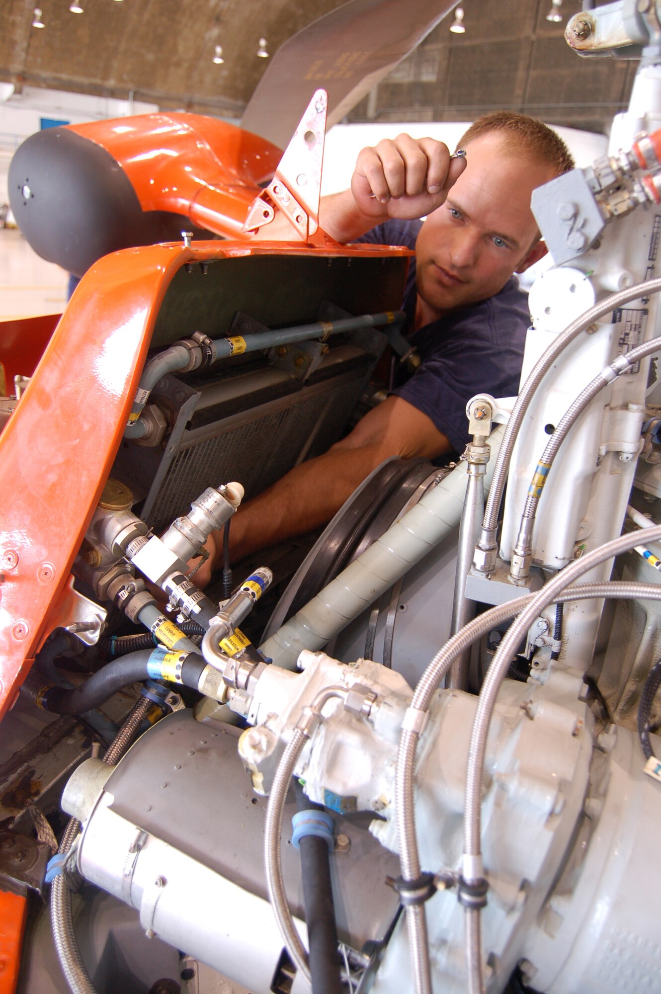 Coast Guard Petty Officer 3rd Class William Restall replaces oil cooler brackets on an HH-65C Dolphin helicopter March 20 at Coast Guard Air Station Borinquen, Puerto Rico. Petty Officer Restall is an aircraft maintenance technician. Coast Guard Air Station Borinquen is based at what used to be Ramey Air Force Base, which closed in 1973. (U.S. Air Force photo/Tech. Sgt. Ben Gonzales) 