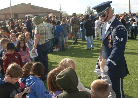 A member of the Air Force Honor Guard Drill Team talks with Holloman children about being on the team and signs autographs. The Drill Team mission is to recruit, retain and inspire for Air Force Recruiting Service. (U.S. Air Force photo by Airman 1st Class John Strong)