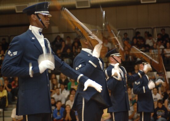 The 16 members of the Air Force Honor Guard Drill Team spin the M-1 rifle with fixed bayonet in a perfect domino effect during a performance at Alamogordo High School. The Drill Team mission is to recruit, retain and inspire for Air Force Recruiting Service. (U.S. Air Force photo by Airman 1st Class John Strong)