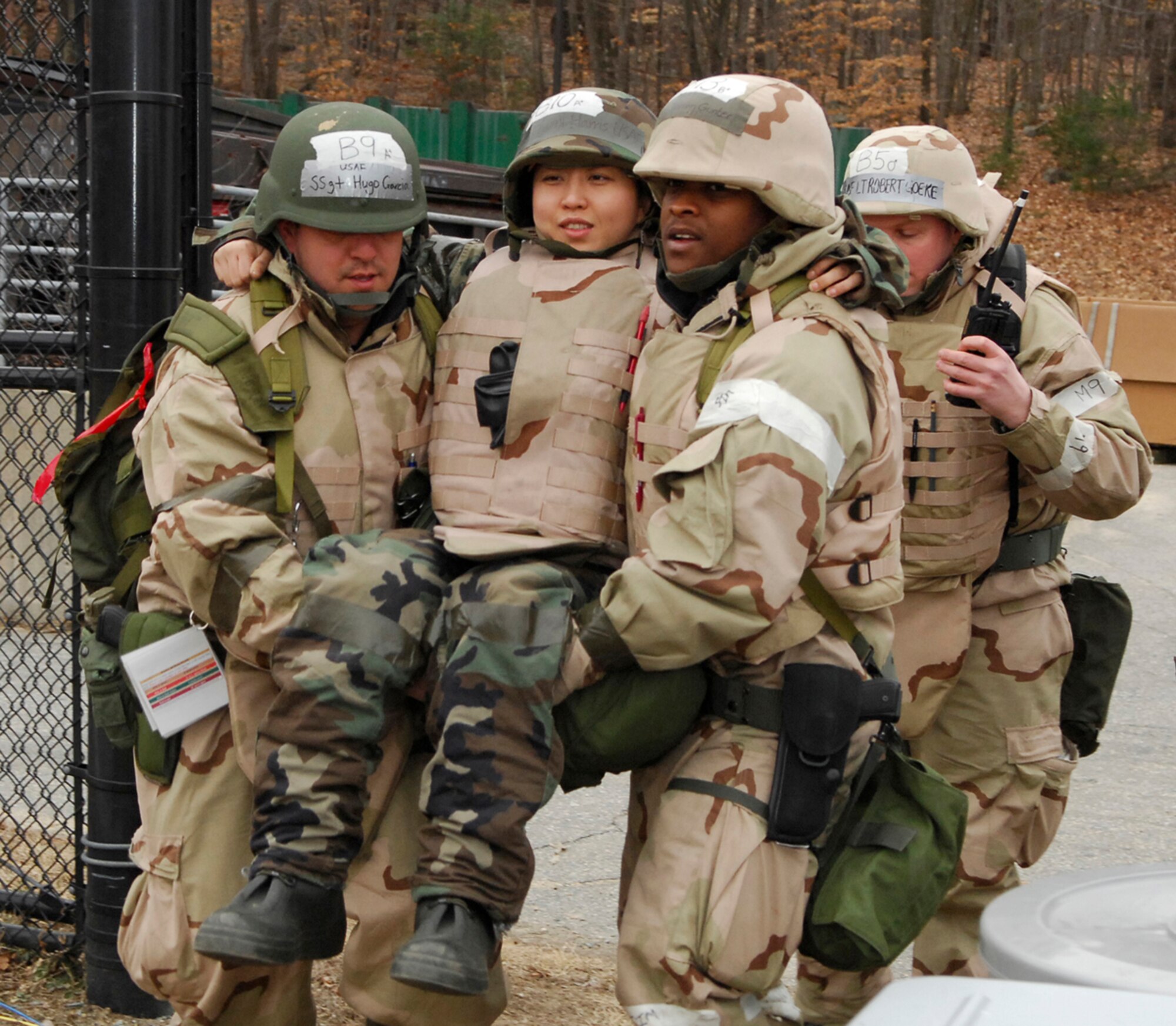 66th Comptroller Squadron members Staff Sgt. Hugo Garcia, left, and Senior Airman Keenan Gunter, right, carry Senior Airman Yunji Harris, 66th CPTS, who was designated as a Self-Aid and Buddy Care 'victim' during the March Base Readiness Exercise. Approximately 140 Airmen "deployed" to Camp Patriot to demonstrate their ability to survive and operate in a field environment. (U.S. Air Force Photo by Mark Wyatt)