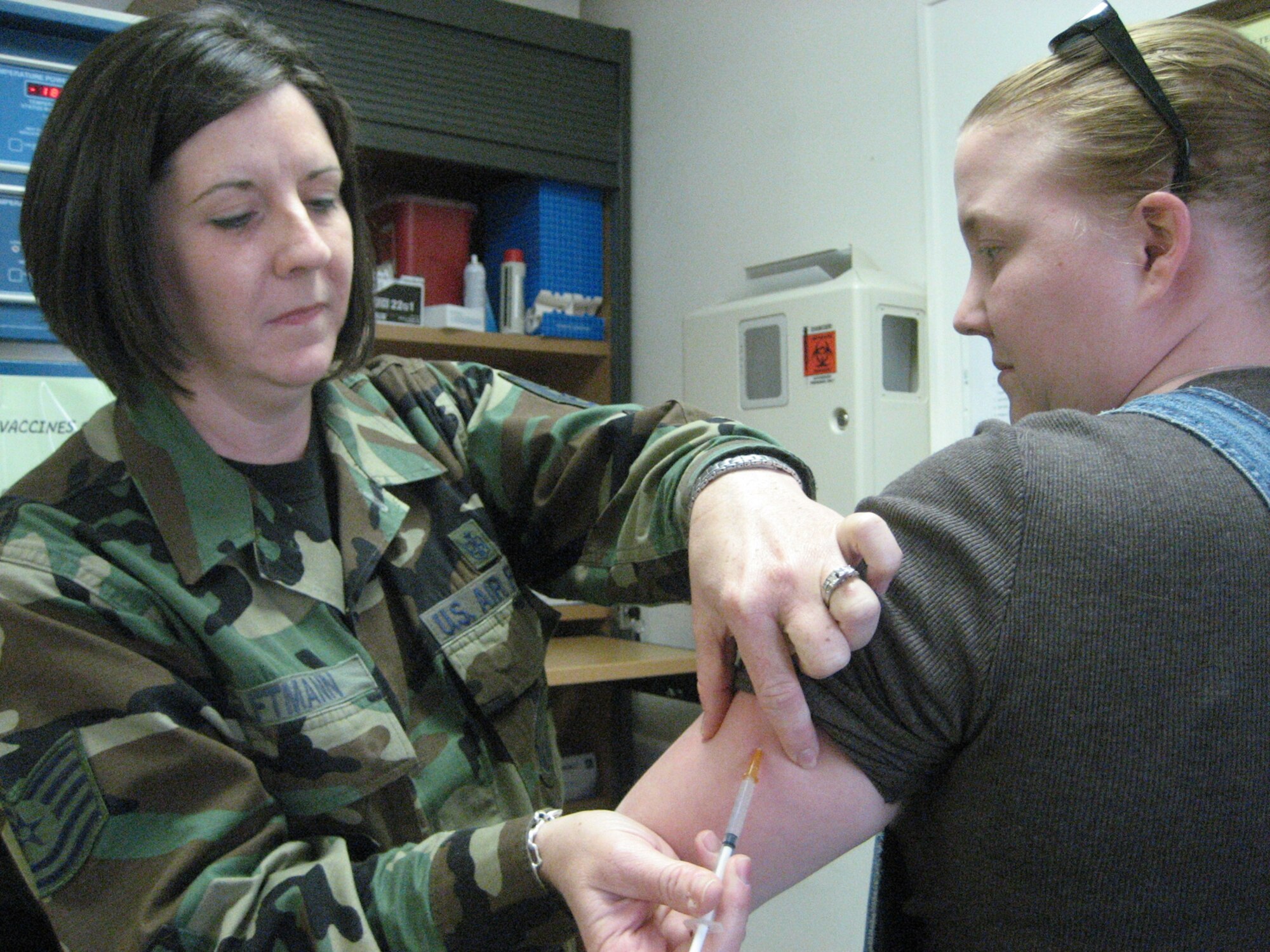 SPANGDAHLEM AIR BASE, GERMANY -- Tech. Sgt. Terri Elftmann, 52nd Medical Operations Squadron NCOIC Allergy/Immunization Clinic, administers an Anthrax shot March 16 at the immunization clinic here to Senior Airman Wendy Salas, 52nd Maintenance Operations Squadron information manager. The shot was Airman Salas’ fifth shot; the initial series of Anthrax shots is six. The Air Force started an anthrax vaccine immunization program for Airmen assigned to high-threat areas. Airman Salas deploys this summer. (US Air Force photo/Staff Sgt. Andrea Knudson)