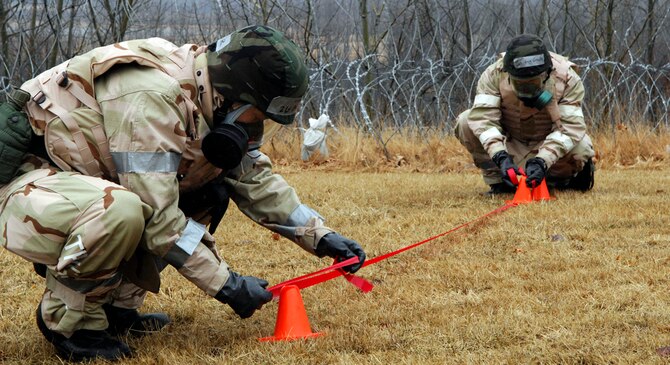 Airmen mark off an area near a simulated Unexploded Ordnance during the March Base Readiness Exercise March 16. The exercise was held in preparation for the upcoming June Operational Readiness Inspection. (U.S. Air Force Photo by Walter Santos)