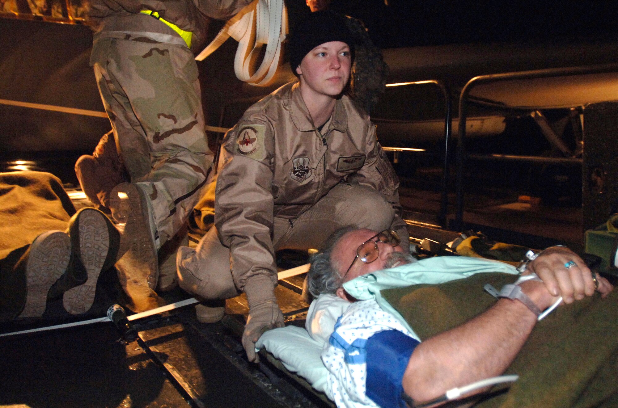 Staff Sgt. Dana Sullivan prepares to load Ray Mitchell onto an aircraft during the first non-stop medical evacuation flight from Bagram, Afghanistan to Landstuhl, Germany, March 21. The normal three- to five-day route through Kuwait has been reduced to an approximately 10-hour direct flight. (U.S. Air Force photo/Tech. Sgt. Cecilio M. Ricardo Jr.)