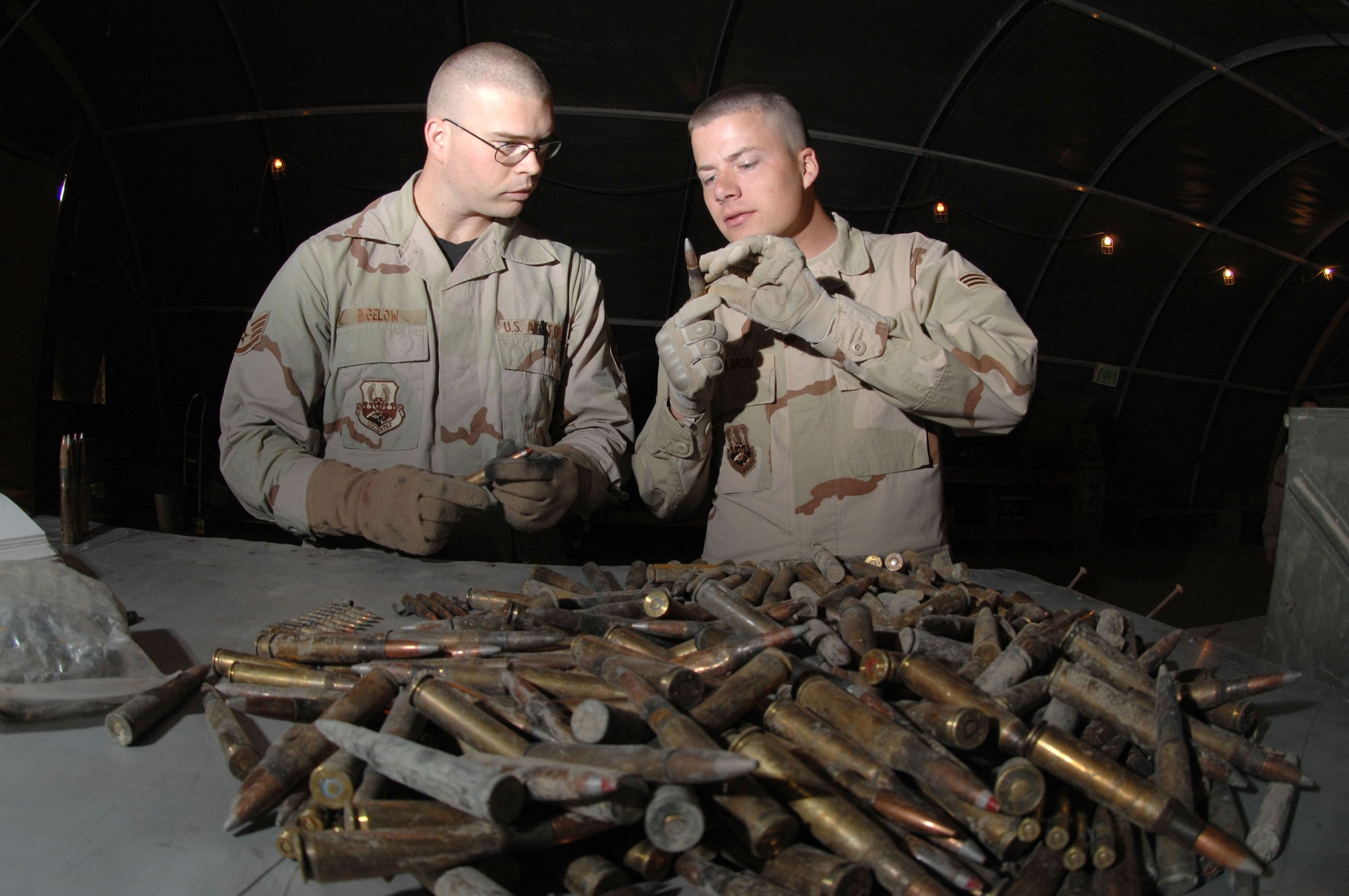 Staff Sgt. Michael Bigelow (left) and Senior Airman David Hallmon inspect unfired ammunition March 21 at Kirkuk Air Base, Iraq. All unserviceable ammo is sent to the explosive ordnance disposal team for detonation. The Airmen are munitions specialists with the 506th Air Expeditionary Group.  (U.S. Air Force photo/Senior Airman Bradley A. Lail)