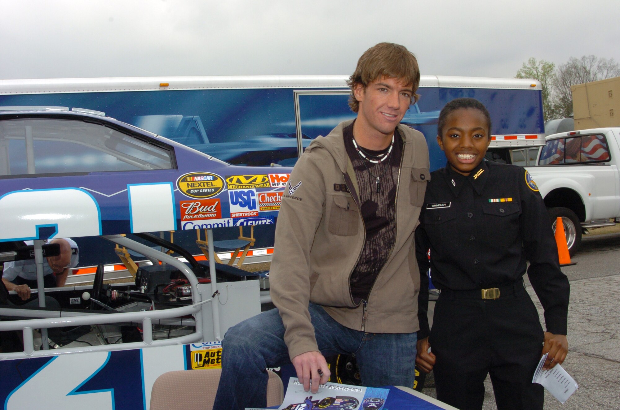 Jon Wood, NASCAR driver of the Air Force sponsored #21 Ford Fusion, takes time for an autograph and a smile with Navy Junior Reserve Officer Training Corps Cadet/Seaman Apprentice Kareema Whimbush of Stephenson High School, Georgia.  Cadet Whimbush was one of thousands of cadets who visited Dobbins ARB during JROTC week for the annual JROTC C-130 orientation flight.  (U.S. Air Force photo/Master Sgt. Stan Coleman)