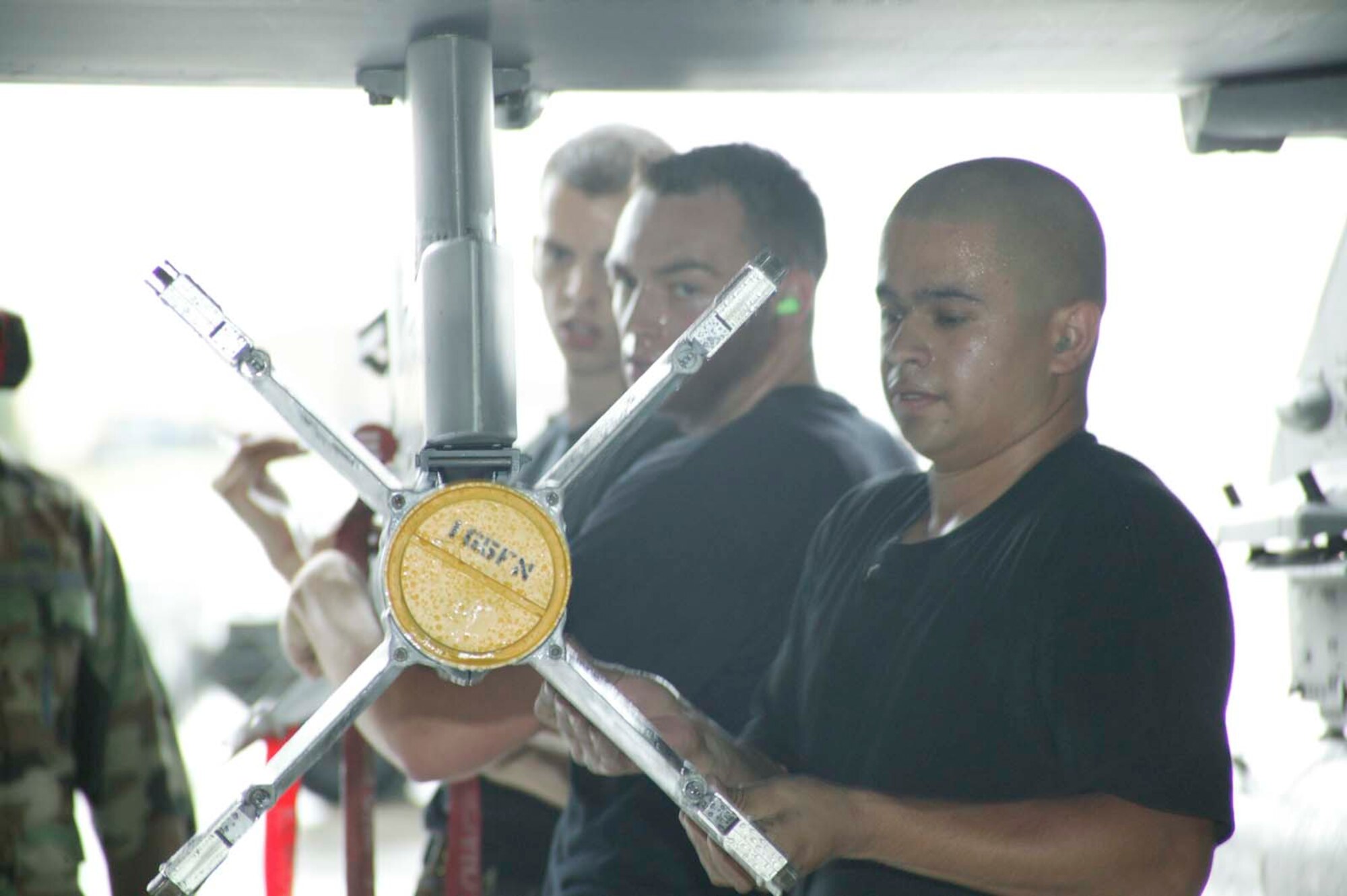 SHAW AIR FORCE BASE, S.C. -- The 79th Aircraft Maintenance Unit load crew, (front to back) Staff Sgt. Miquel Duarte and Senior Airmen Steve Dash and Jacob Tolman, load an AIM-9 Sidewinder onto an F-16 during the Load Crew of the Year competition March 16 in hangar 1200. Each of the four crews who competed had previously won a quarterly load crew competition to earn their position in the annual event. The winning crew takes the title and carries the trophy home to their squadron. (U.S. Air Force photo/ Senior Airman Holly MacDonald)