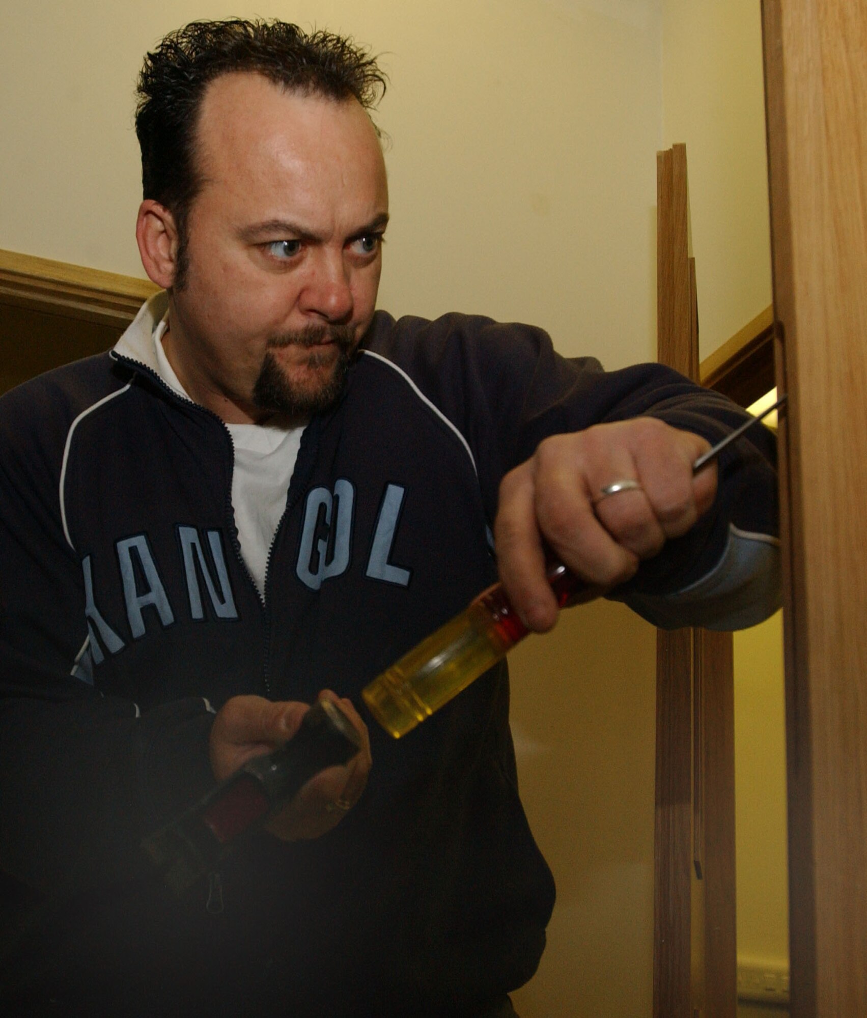 John Cooper, 100th Civil Engineer Squadron Lock Shop, and a Ministry of Defence civilian, chisels out part of the door edge, before installing an Assa mortice lock on a conference room door March 14, 2007, in the 95th Reconnaissance Squadron, in Building 707. The lock smiths often have to make minor adjustments to doors and fittings to ensure locks fit properly and are secure. (U.S. Air Force photo by Airman Brad Smith)                                                               