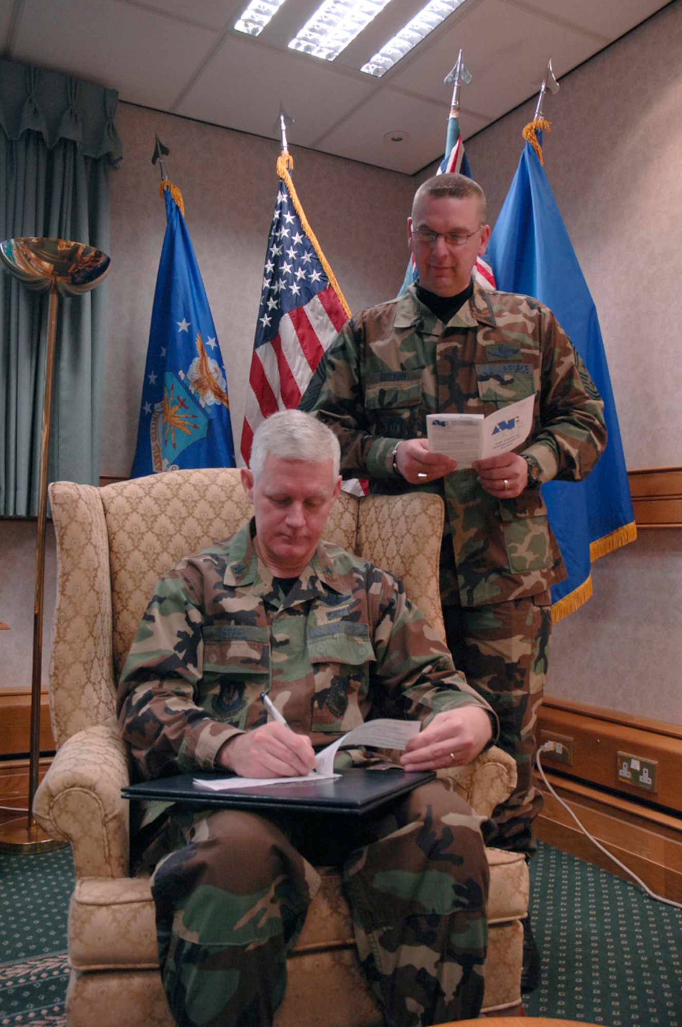 Brig. Gen. Robert P. Steel, 48th Fighter Wing commander signs a pledge to the Air Force Assistance Fund Monday at the begining of the campaign's open season as Command Chief Master Sgt. Jerry K. Sutton looks on. The AFAF campaign will be ongoing thorough April 29. (US Air Force photo by Airman 1st Class Erika Brooke)