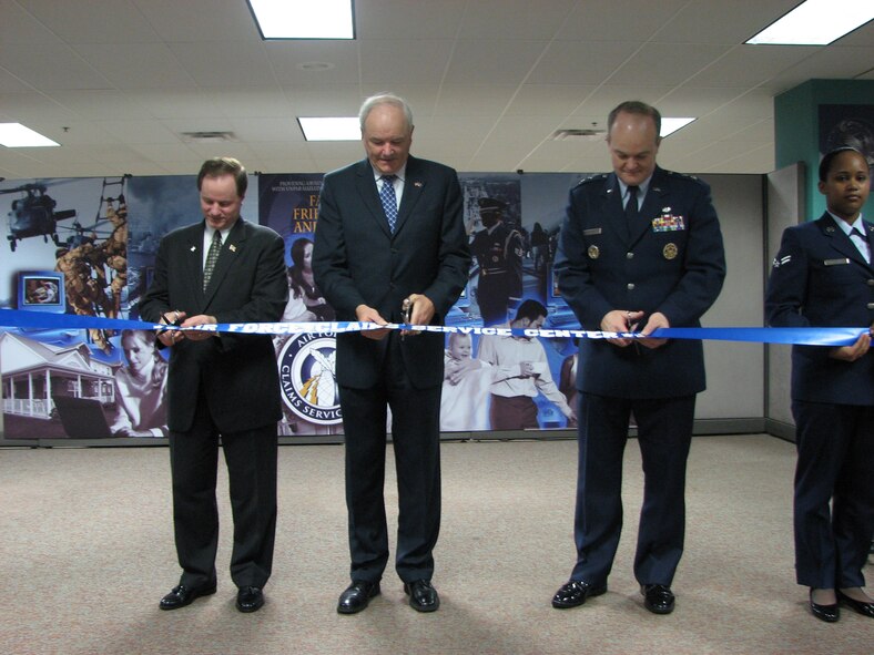 The Air Force transformed processing of personal property claims with the March 23 dedication of the new Air Force Claims Service Center in Kettering, Ohio. The single center now provides Air Force people worldwide with on-line claims filing and 24/7 toll-free, live personal assistance via telephone. Cutting the ribbon at the AFCSC from left to right is Zack Gaddy, Director of the Defense Finance and Accounting Service, Michael Wynne, Secretary of the Air Force and Maj. Gen. Jack Rives, Air Force Judge Advocate General.   Assisting them is Airman First Class Sherri Igartua of the AFCSC.  Air Force Photo by Tech. Sgt. Steve Moore.
