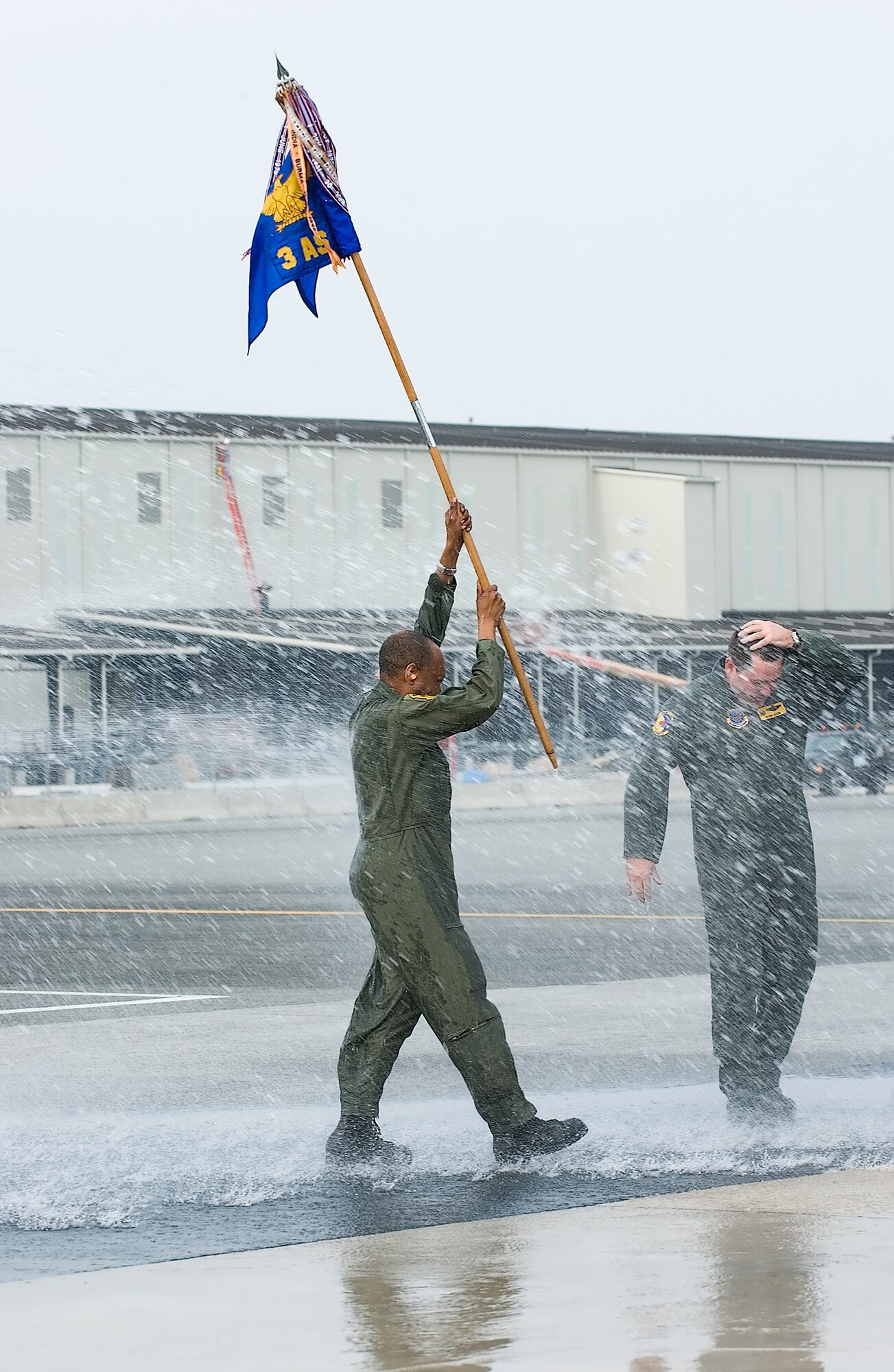 DOVER AIR FORCE BASE, Del. -- Master Sgt. Dexter Joseph, 3rd AS flight engineer superintendent, holds the 3rd AS guidon high as he is sprayed with water after the squadron’s final C-5 flight landed. (U.S. Air Force photo/Jason Minto)