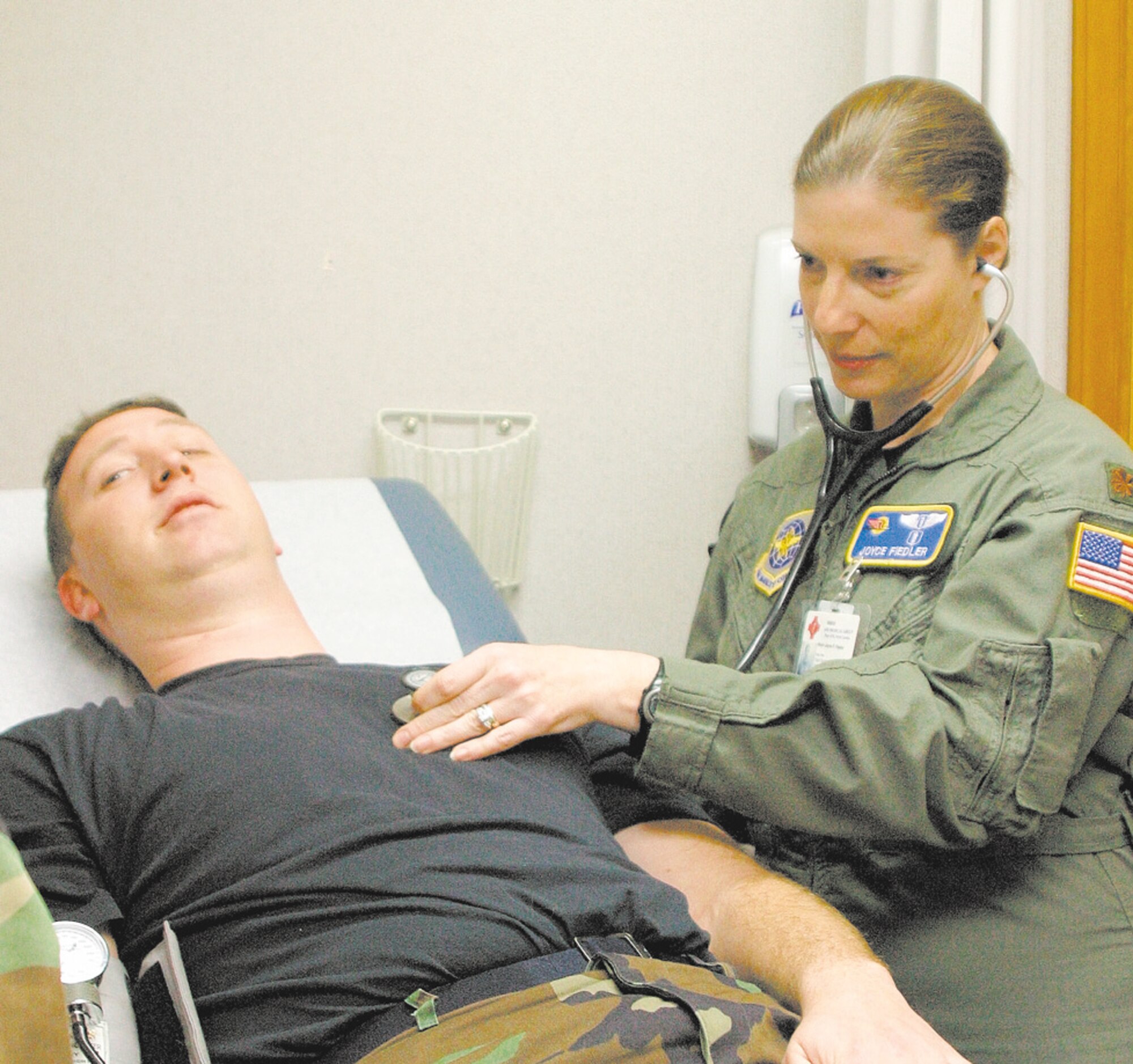 Maj. Joyce Fiedler listens to a patient's heartbeat during a routine check-up at the Pope Flight Medical Clinic.