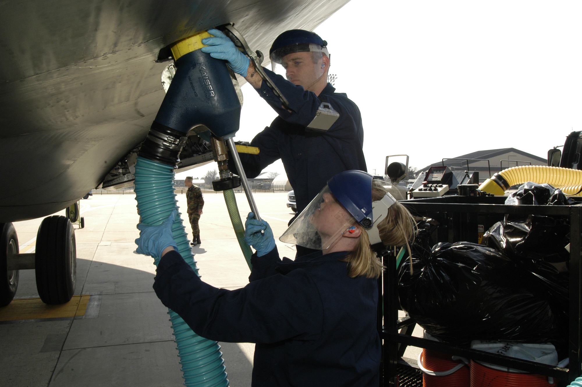 DOVER AIR FORCE BASE, Del. -- 2nd Lt. Nicole Langley, 436th Airlift Wing Public Affairs, experiences one of Dover AFB’s dirtier jobs, as she assists Airman 1st Class Douglas Kellogg, 436th APS Fleet Services Flight, in attaching a drainage tube to a C-5 here, to remove the waste from the aircraft’s lavatories. (U.S. Air Force photo/Senior Airman James Bolinger)                              