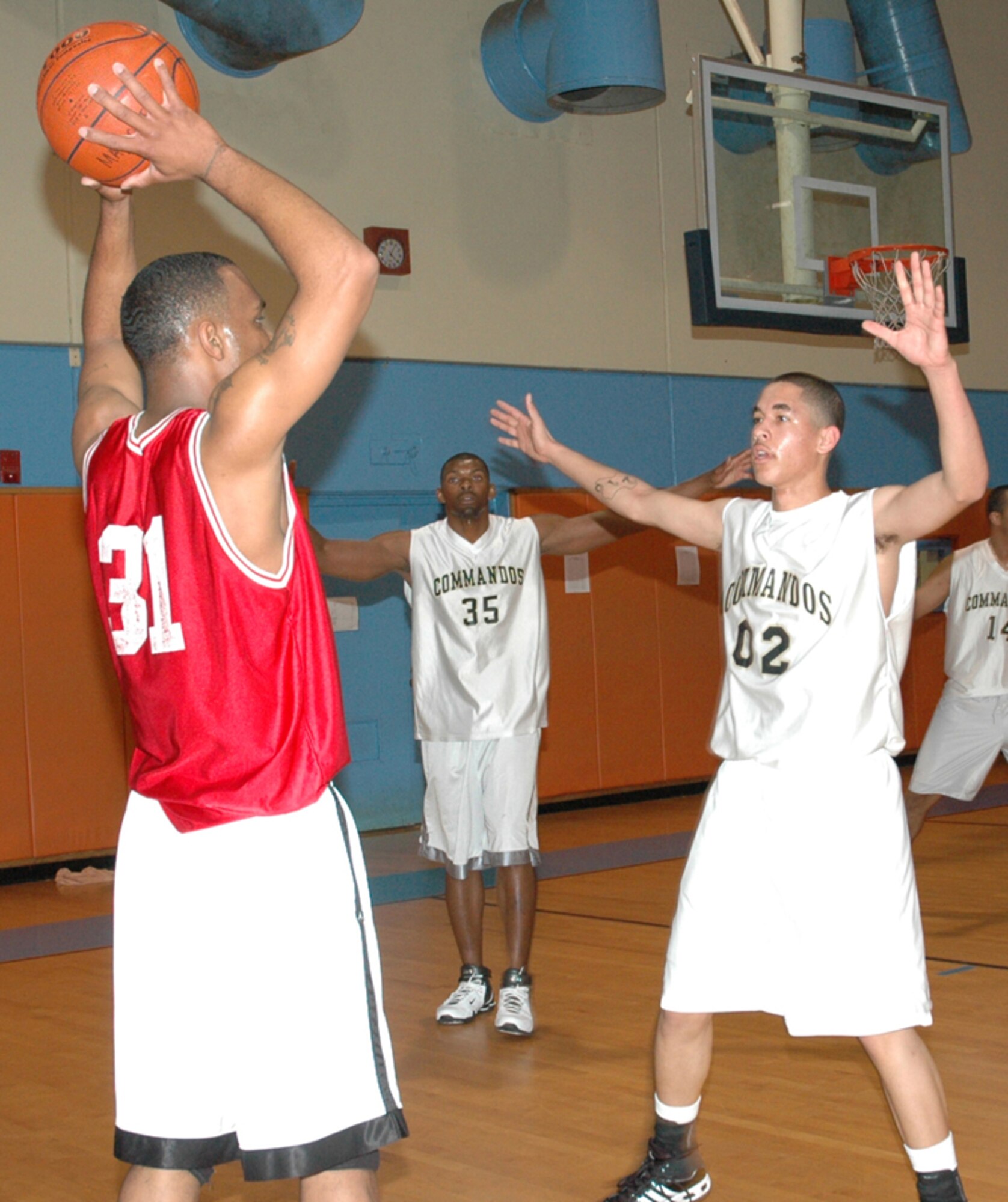 Andre Harp-Thomas, number two, 1st Special Operations Logistic Readiness Squadron and Jammar Major, number 35, 1st Special Operations Aircraft Maintenance Squadron defend against a player from Atlanta Naval Air Station during a March Madness Tournament at Mayport Naval Station in Jacksonville, Fla. (U.S. Air Force photo by Staff Sgt. Mareshah Haynes)