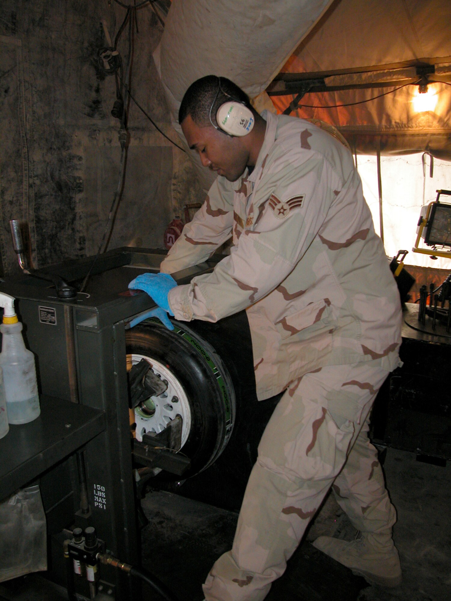 BALAD AIR BASE, Iraq -- Senior Airman Jon McNairy, from the 332nd Expeditionary Maintenance Squadron's Crash Recovery, Wheel/Tire shop uses a machine to break the bead on an F-16 wheel/tire assembly. Airmen from the crash recovery, wheel/tire shop repair about 30 tires a week.  Airman McNairy is deployed here from the 35th Maintenance Squadron, Misawa Air Base, Japan.  (U.S. Air Force photo/MSgt. Bryan Ripple)