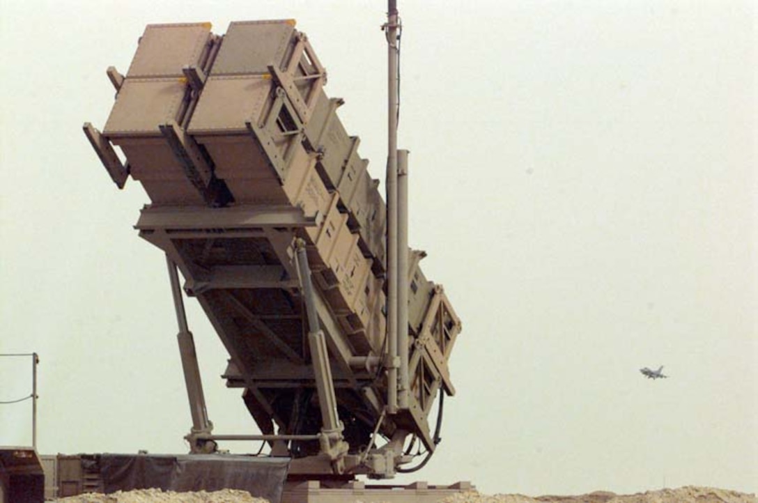 Army Patriot Missile Launcher is raised to its readied position, while in the distance a F-16C comes in for a landing. During Secretary Cohens current trip to Southwest Asia, he visited a Patriot missile site, manned by members of the  43rd Air Defense Artillery Regiment, Fort Bliss, Texas.