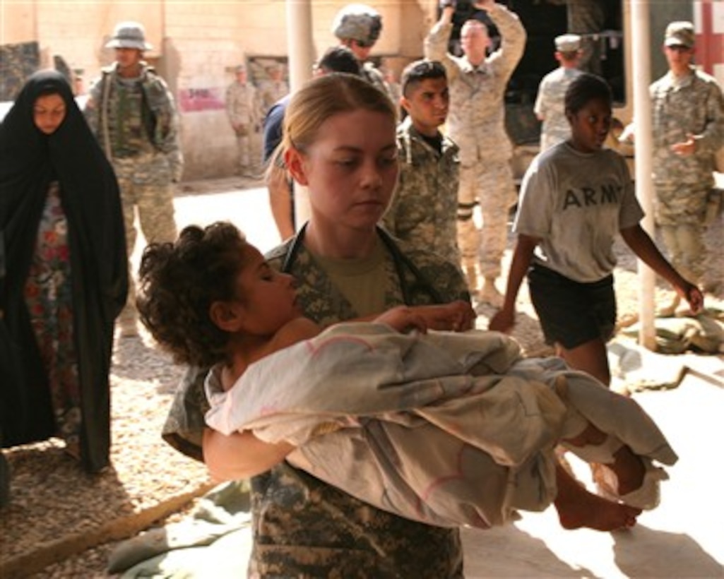 A U.S. Army soldier carries a wounded Iraqi child into the Charlie Medical Center on Camp Ramadi, Iraq, for medical evaluation on March 20, 2007.  The child is one of several Iraqis who were attacked by anti-Iraqi forces after they allegedly told coalition forces of insurgent activity in the 1st Battalion, 6th Marine Regiment area of operations.  