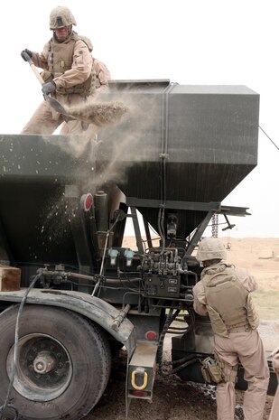AL TAQADDUM, Iraq (March 26, 2007) ? Marines with Engineer Support Company, 8th Engineer Support Battalion, 2nd Marine Logistics Group (Forward), repair nearby roads by filling improvised explosive device craters with quick-drying concrete March 26.  ?The work helps Marines and civilians get around easier and also keeps Marines safer when they convoy on already dangerous roads,? said Cpl. Michael Moceri, a heavy equipment operator and Tacoma, Wash., native with the company.