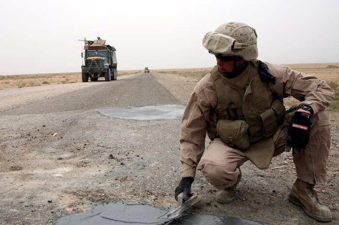 AL TAQADDUM, Iraq (March 26, 2007) ? A Marine with Engineer Support Company, 8th Engineer Support Battalion, 2nd Marine Logistics Group (Forward), smoothes out some quick-drying concrete in a pothole on a road near Al Taqaddum March 26.  The Marines with 8th ESB repaired the road of improvised explosive device craters for the safety of coalition and Iraqi forces.