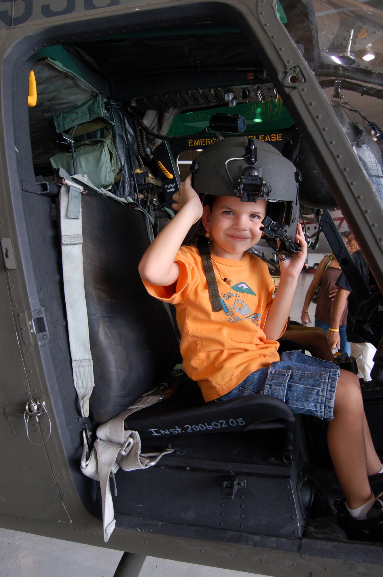 A child tries on a helmet in a Customs and Border Patrol OH-58 helicopter during a March 22 open house at Coast Guard Air Station Borinquen, Puerto Rico. Coast Guard Air Station Borinquen is located at what used to be Ramey Air Force Base, which closed in 1973. Approximately 500 visitors got a firsthand look at today's military members and equipment in Puerto Rico, and to see an historic C-54 cargo plane used during the Berlin Airlift. (U.S. Air Force photo/Tech. Sgt. Ben Gonzales)
