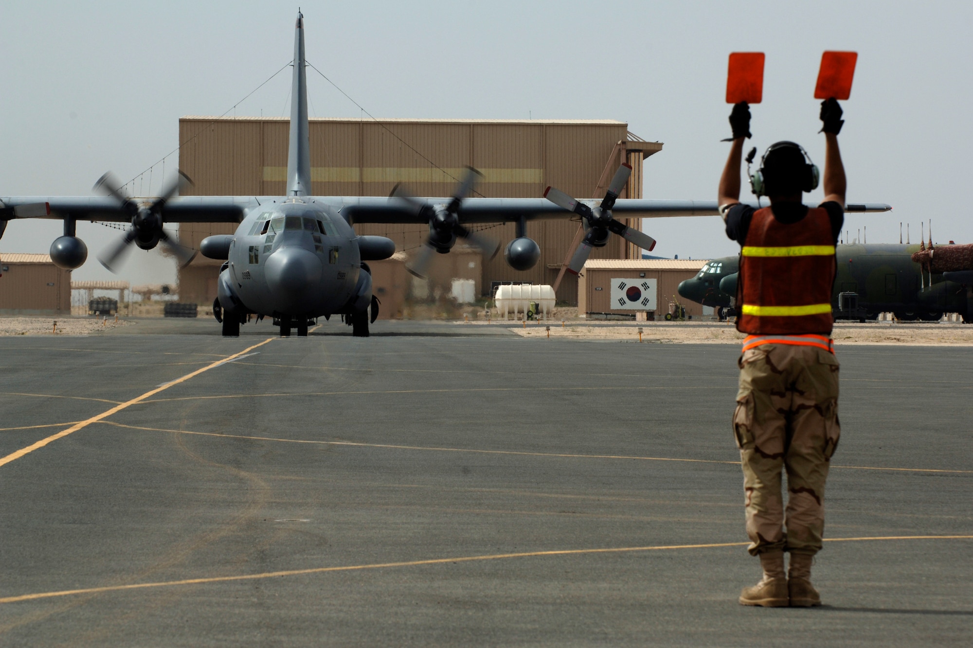 SOUTHWEST ASIA -- A1C Lance Griffin Sr. from the 43d Red Aircraft Maintenance Unit, directs newly awarded command pilot Col Ronald J. Celentano onto the aircraft parking ramp at an undisclosed location in southwest Asia on Friday, 23 Mar 07.  Col Celentano surpassed the 3000 flying hour milestone on Friday, 23 Mar 07 to earn his command pilot wings. (U.S. Air Force photo by Tech. Sgt. Edward D. Holzapfel) (Released)