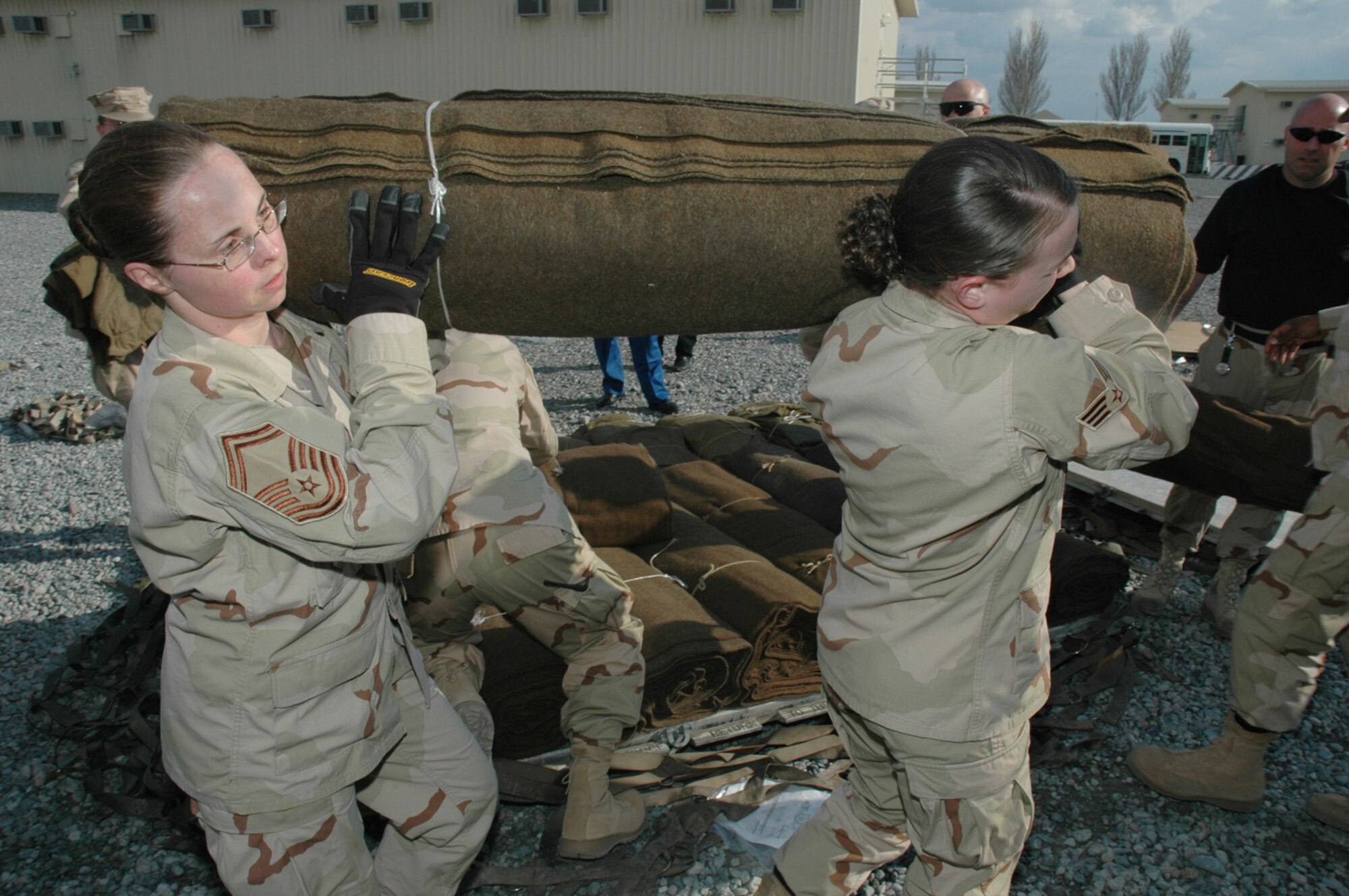 Senior Master Sgt. Jacqueline Larrison and Senior Airman Michelle Henry, 376th Expeditionary Logistics Readiness Squadron, were among the many Liberandos who came out to help load relief trucks with humanitarian cargo from the Slovak Republic to Kyrgyzstan.  (Air Force Photo/Master Sgt. Daniel Nathaniel)