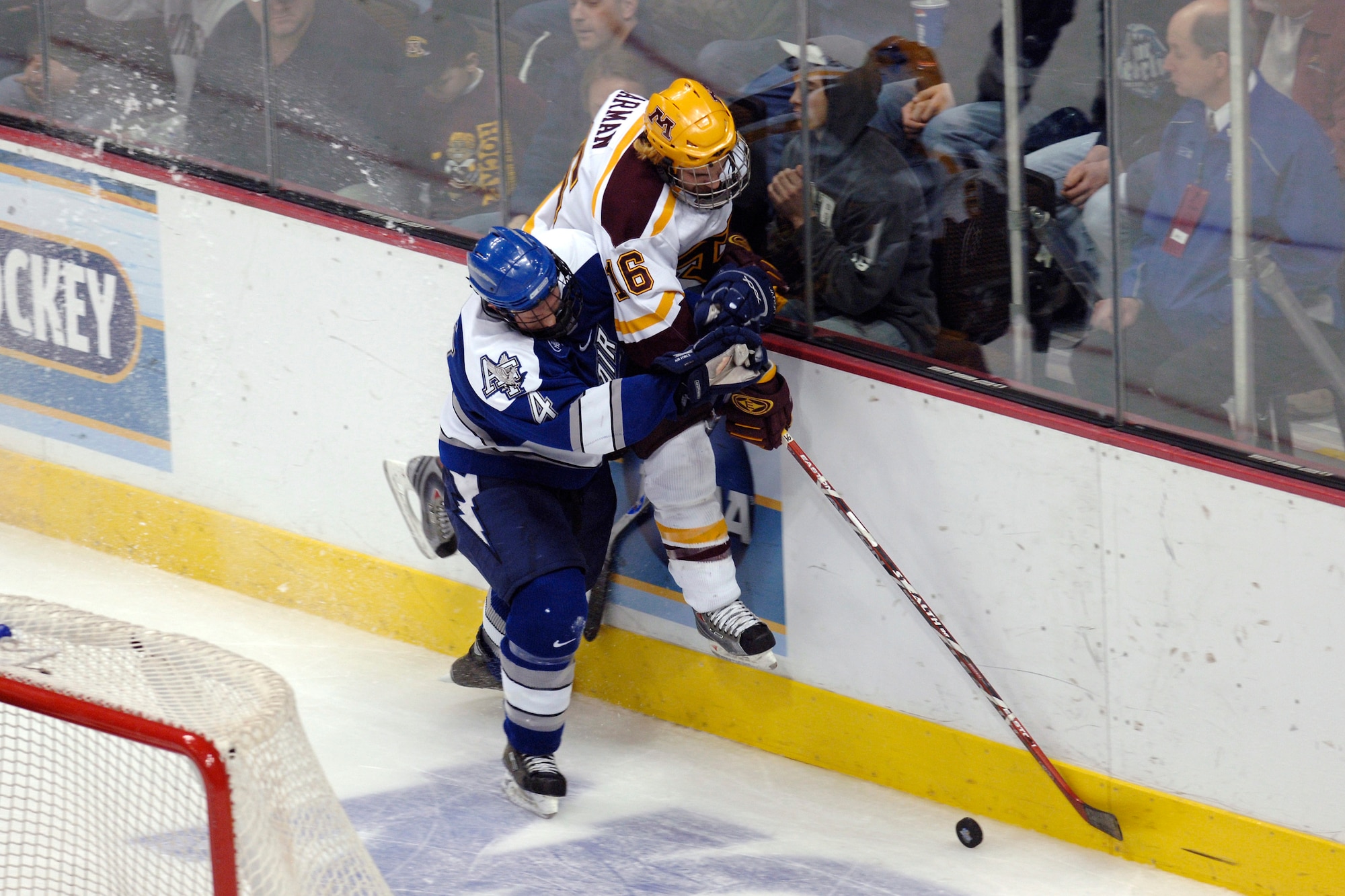 Falcon defenseman Greg Flynn finishes his check on Minnesota's Mike Carman during the NCAA West Regional March 24 at the Pepsi Center. Flynn played against his younger brother, Ryan, a right wing, in the game won by the Golden Gophers 4-3. (U.S. Air Force photo/Dave Armer)