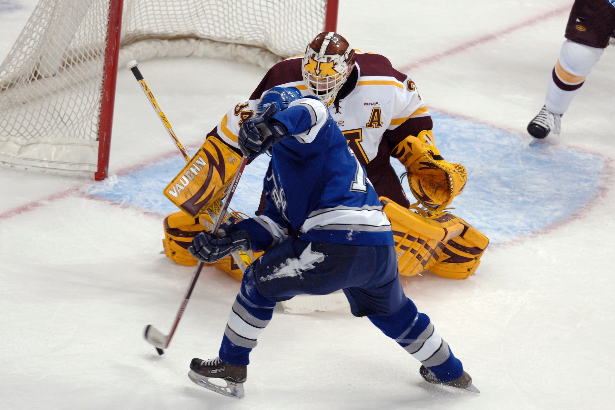 Falcon right wing Mike Phillipich goes to his back hand on Minnesota goaltender Kellen Briggs during the NCAA West Regional March 24 at the Pepsj Center in Denver. Phillipich assisted on Andrew Ramsey's go ahead goal, in Air Forces 4-3 loss to the Gophers. (U.S. Air Force photo/Dave Armer)