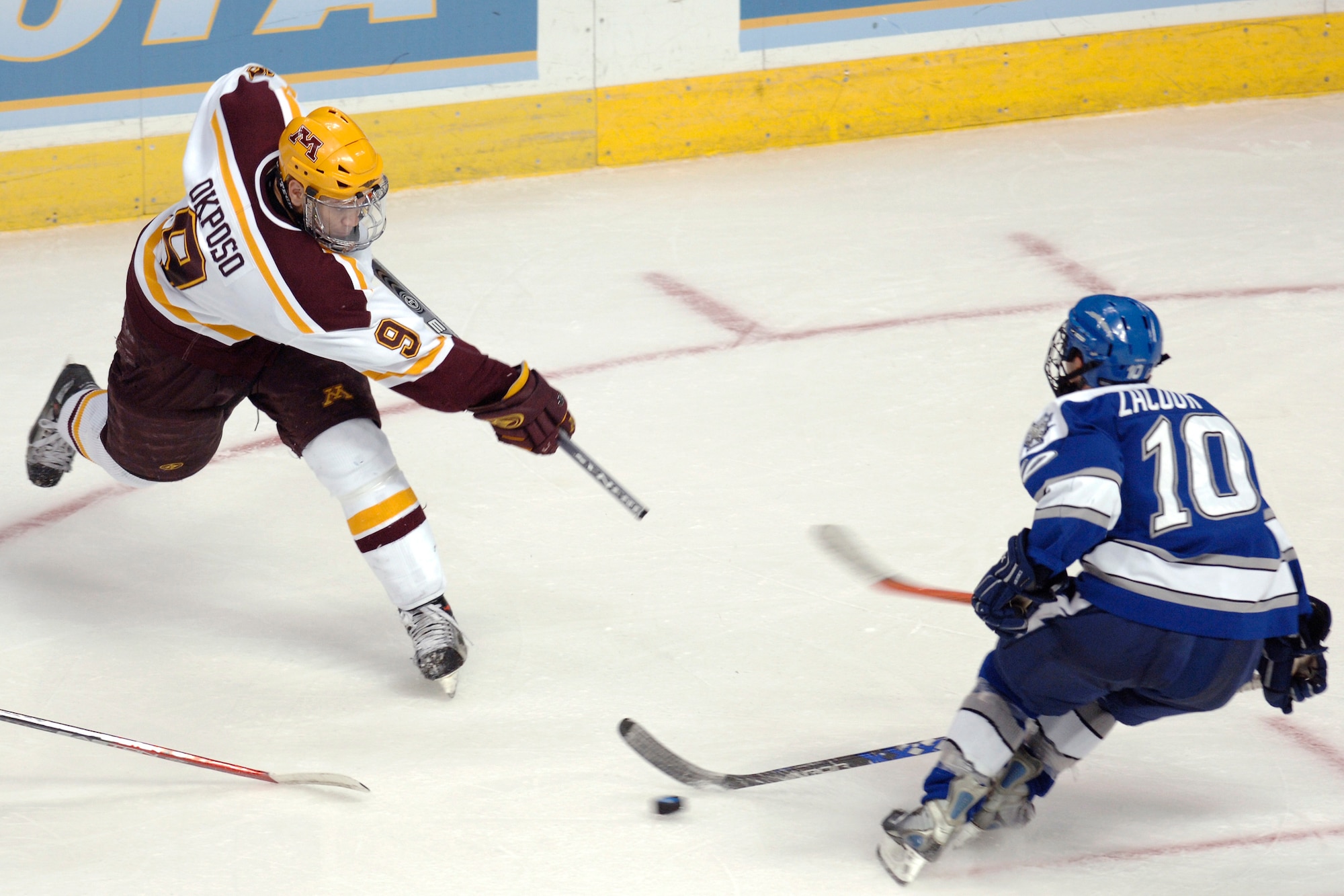 Minnesota center Kyle Okposo breaks his stick taking a slap shot in front of Falcon Theo Zacour during the NCAA West Regional March 24 at the Pepsj Center in Denver. Zacour is one of eight senior Falcons to graduate this year. (U.S. Air Force photo/Dave Armer)