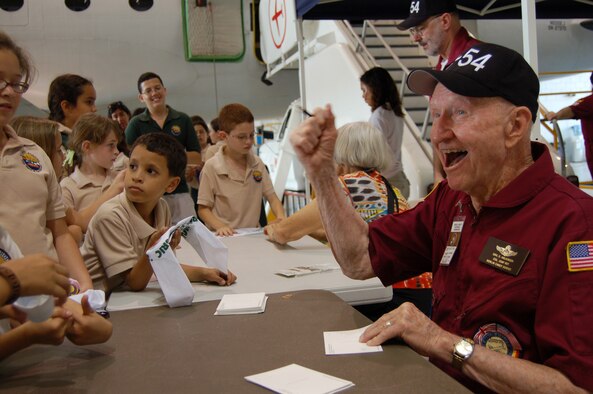 Retired Col. Gail Halvorsen signs autographs for children from the Ramey School March 22 at Coast Guard Air Station Borinquen, Puerto Rico. Colonel Halvorsen, also known as the Berlin Candy Bomber, flew C-54 Skymasters during the Berlin Airlift and parachuted candy to children from his airplane. This was Colonel Halvorsen's first return to what was once Ramey Air Force Base since 1949, when he flew C-54 missions from Puerto Rico to South America. (U.S. Air Force photo/Tech. Sgt. Ben Gonzales)