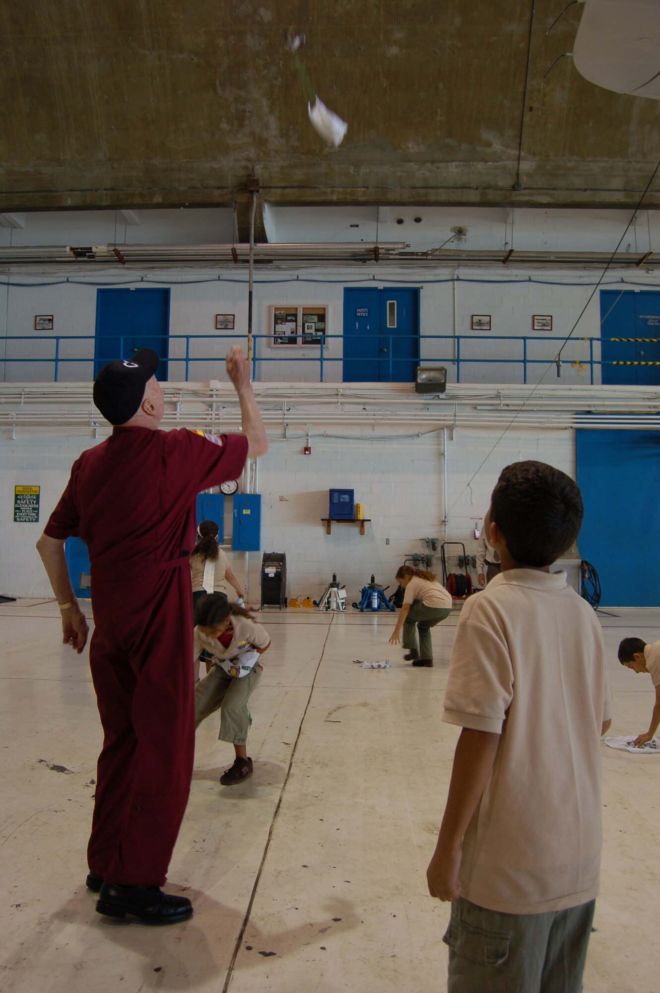 Retired Col. Gail Halvorsen shows Ramey School children how he threw candy bombs March 22 at Coast Guard Air Station Borinquen, Puerto Rico. Colonel Halvorsen, also known as the Berlin Candy Bomber, flew C-54 Skymasters during the Berlin Airlift and parachuted candy to children from his airplane. This was Colonel Halvorsen's first return to what was once Ramey Air Force Base since 1949, when he flew C-54 missions from Puerto Rico to South America. (U.S. Air Force photo/Tech. Sgt. Ben Gonzales)