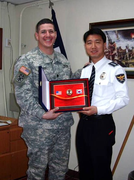 SUWON, Republic of Korea --  Lt. Col. John Chavez, commander of the 1-43 Air and Missile Defense Battalion here, presents Mr. An Han Sik of the Gyeonggi Police Station with a plaque in appreciation of the support provided by the Korean National Police during the unit’s vehicular convoys. The cooperation of the KNP has made for smoother convoys and increased safety for both the Army and the Korean public. (U.S. Army photo)
