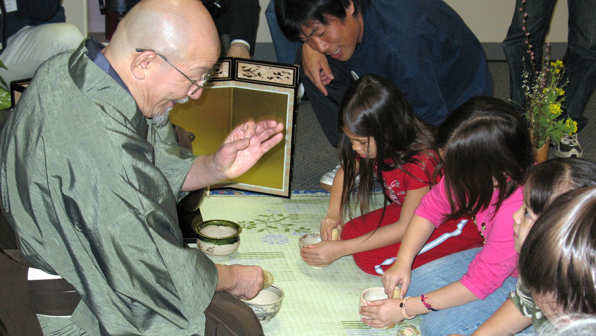 Yokota residents sit in a traditional Japanese tea ceremony at Yokota's East Youth Center. Japanese guests showed Yokota residents how to make, serve and drink in the ceremony as well as present Hina Dolls and oragimi. (U.S. Navy Photo by MCSN A.C. Rainey)