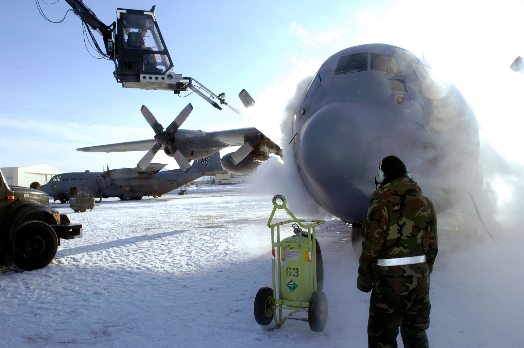 ELMENDORF AIR FORCE BASE, Alaska -- Senior Airman Sandro Cardona, 703rd Aircraft Maintenance Squadron, deices the a C-130 from 517th Airlift Squadron before it leave for Yokota Air Base, Japan. After 43 years of continuous service in Alaska, the C-130 is leaving to fulfill a reorganization of aircraft basing to make its mission more efficient. The 517th AS is converting C-17s and the C-130s relocating to Yokota AB will replace the "E" models and will add two more "H" models to Dyess Air Force Base, Texas, fleet. (U.S. Air Force photo by Airmen 1st Class Jonathan Steffen)