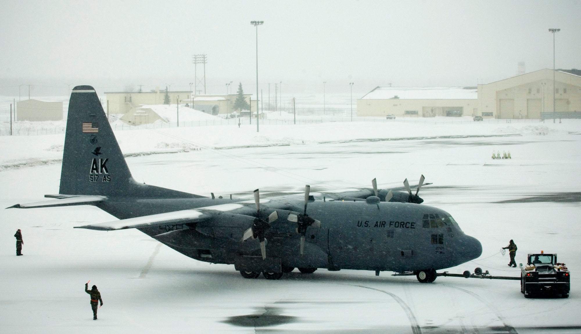 ELMENDORF AIR FORCE BASE, Alaska - A snow covered C-130 is towed into place for post flight inspections after a ceremonial shut down of the remaining C-130s attached to the 517 Airlift Squadron. After 43 years of continuous service in Alaska, the C-130 is leaving to fulfill a reorganization of aircraft basing to make its mission more efficient. (U.S. Air Force photo by Senior Airman Garrett Hothan)