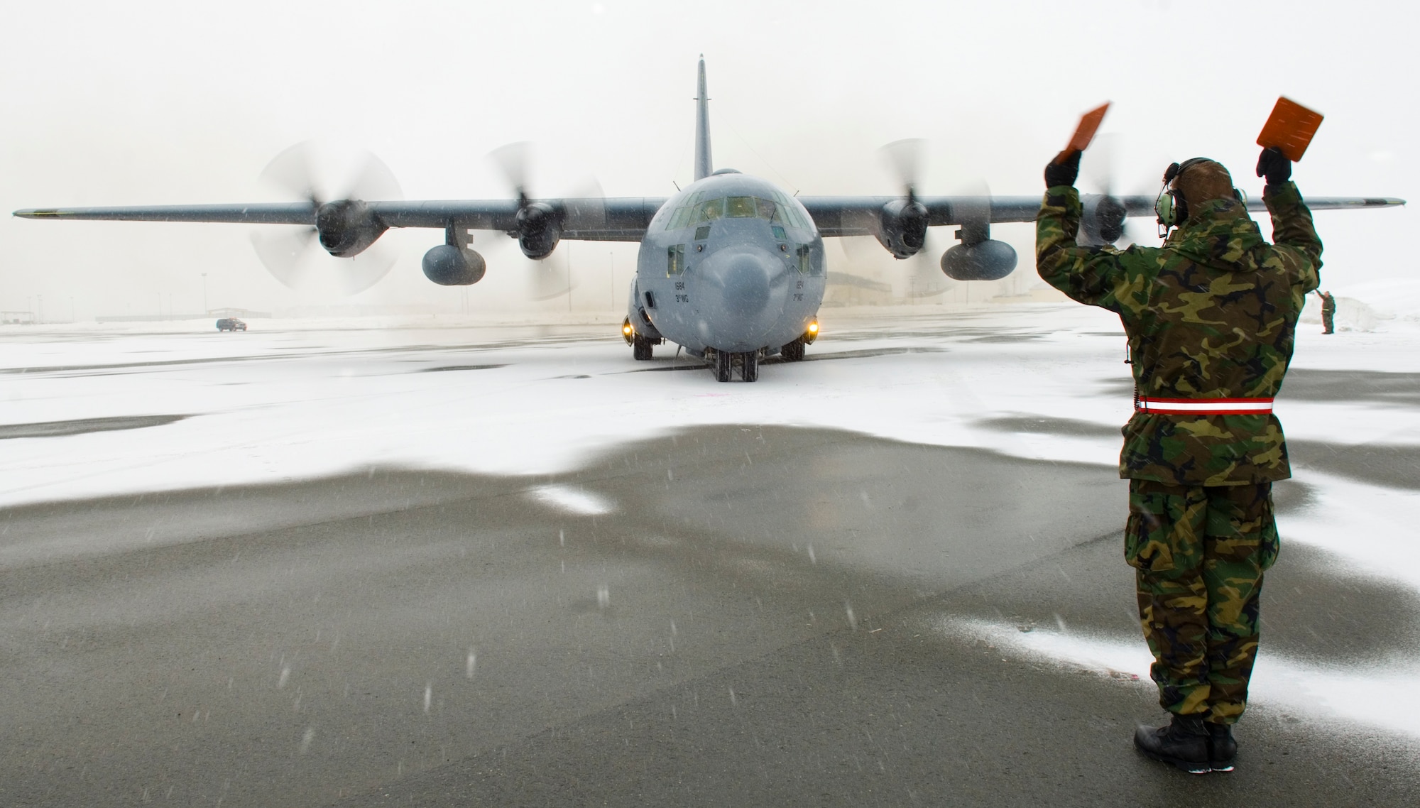 ELMENDORF AIR FORCE BASE, Alaska - Staff Sgt. Joseph Langer, 703rd Aircraft Maintenance Squadron, marshals the final C-130 into place for a ceremonial shut down. After 43 years of continuous service in Alaska, the ceremonial shut down of two of the three remaining C-130 stationed here marked the end of the C-130 era with the 517th Airlift Squadron. (U.S. Air Force photo by Senior Airman Garrett Hothan)