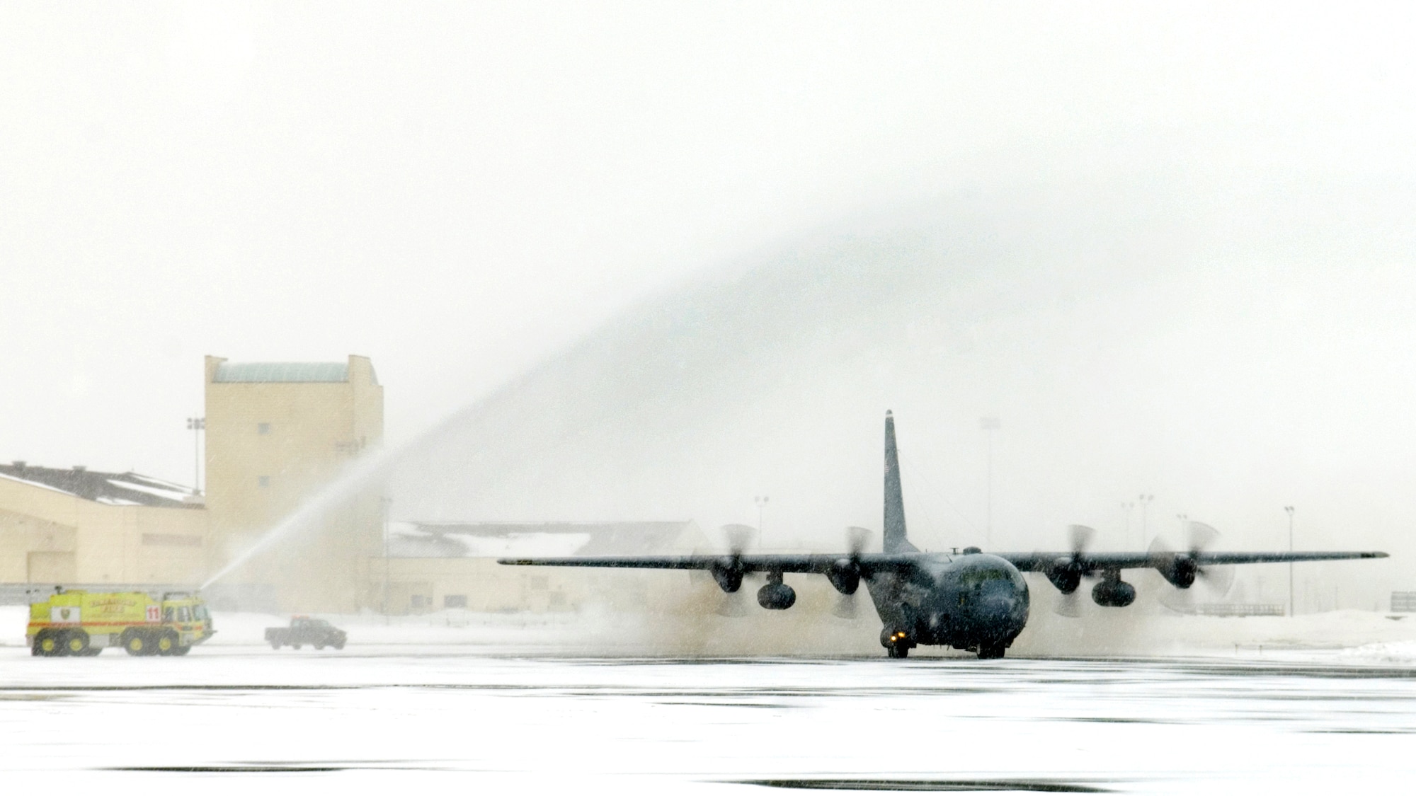 ELMENDORF AIR FORCE BASE, Alaska - A torrent of water from a fire truck washes over a C-130 from the 517th Airlift Squadron as it returns from its last flight. After 43 years of continuous service in Alaska, the C-130 ceremonial shut down of two of the three remaining Hercules stationed here marked the end of the an era with the 517th AS. (U.S. Air Force photo by Senior Airman Garrett Hothan)