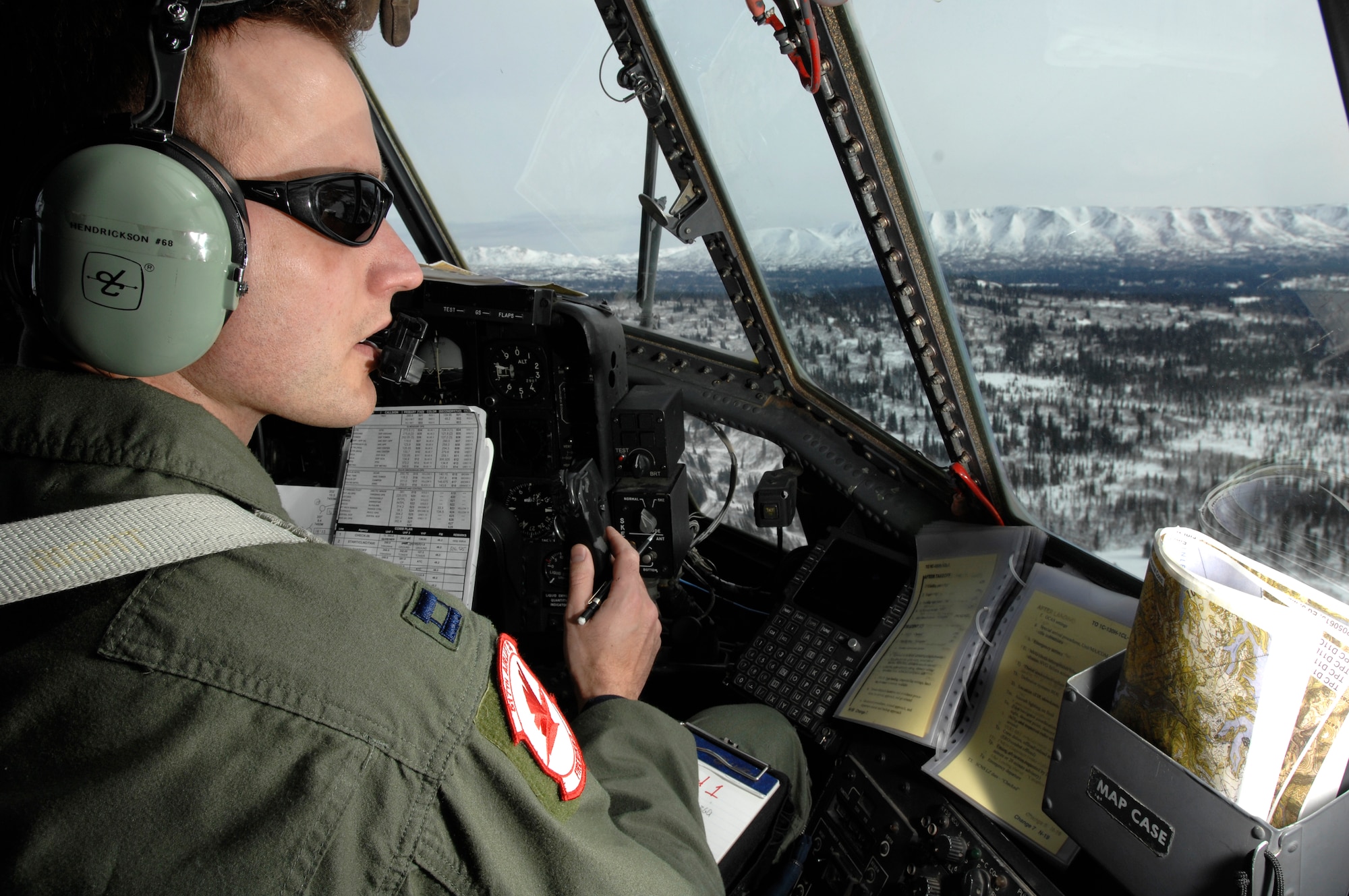 OVER ALASKA -- Capt. Ryan Hendrickson looks out over the vast Alaska wilderness during the final C-130 flight for the 517th Airlift Squadron March 23. After 43 years of continuous service in Alaska, the flight marked the end of the C-130 era at the 517th AS and will see the C-17 taking over the mission soon. The flight was also significant for other reasons to Captain Hendrickson, who proposed to his girlfriend, Charui, shortly after landing. (U.S. Air Force photo by Tech. Sgt. Keith Brown)