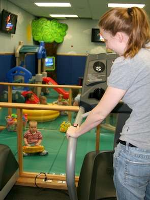 Shara Cooley, tries out one of the treadmills at the Family Fitness Center while watching her daughter, Emily play in the children’s area. 