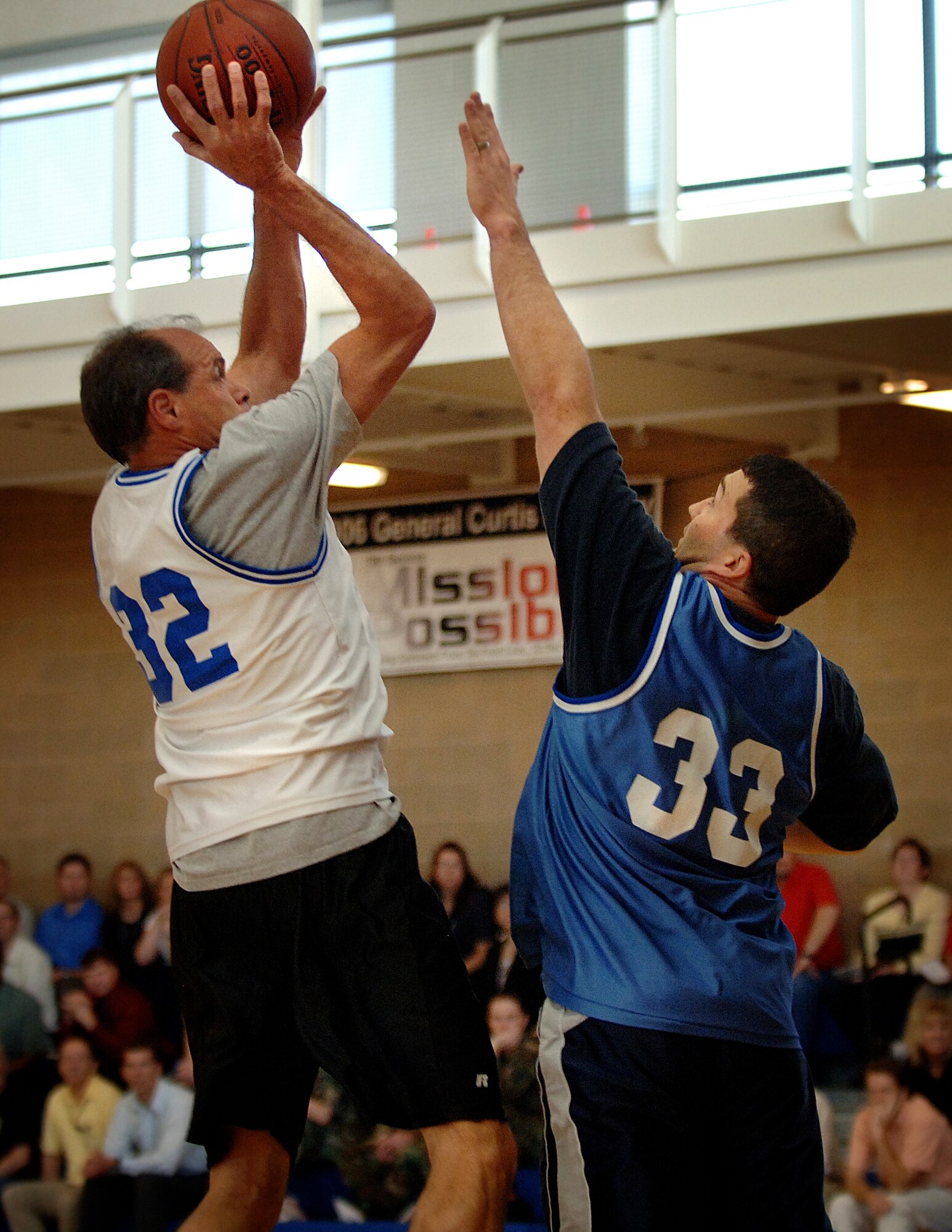 Don Cazel (left), Executive Director, Ogden Air Logistic Center, scores an easy goal against Master Sgt. Kenneth Elliott, 75th Operations Support Squadron, after rebounding a teammates shot attempt during the commanders vs. chiefs basketball game commemorating the start of this year's Air Force Assistance Fund campaign at Hill Air Force Base, Utah.  Team Hill members in attendance were also treated to a half-time dance show put on by the ladies of the NBA's Utah Jazz dance team. Members in attendance also received door prizes presented by Kelsey Brigel, Miss Teen Utah as part of the event's festivities.  (USAF photo by Efrain Gonzalez, Civ., 75 Communications Squadron, Hill Air Force Base, UT)