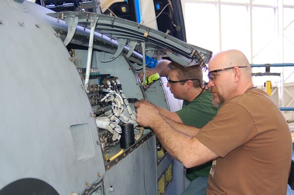 Dennis Miller (right) and Chris Ward inspect the wiring in A-10 panels before sending the aircraft to the fuel dock. Photo by Bill Orndorff