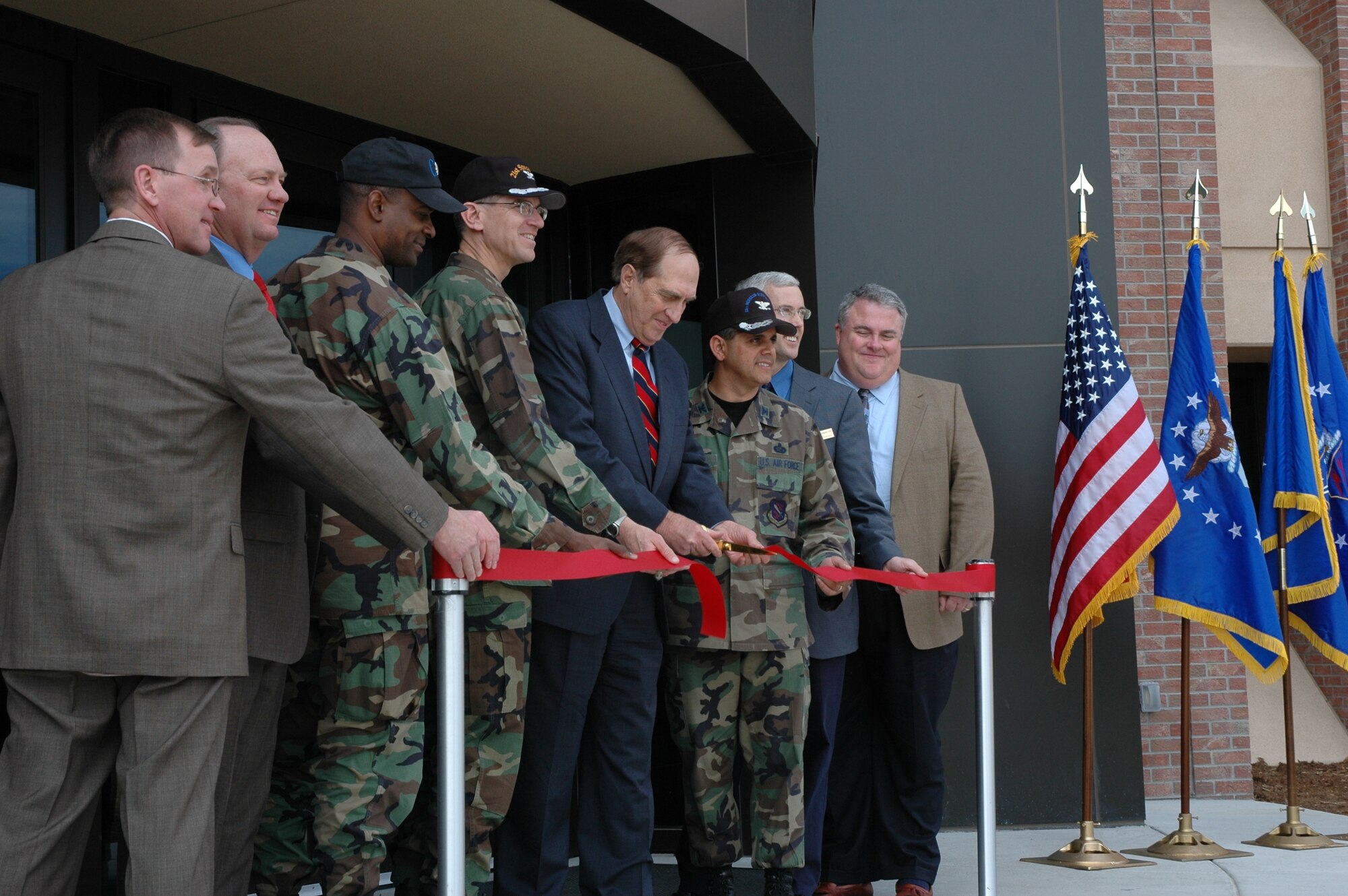 (Left to right) Lt. Col. Derrek Sanks, 21st Civil Engineer Squadron Commander, Col. Jay G. Santee, 21st Space Wing commander, Joel Hefley, former U.S. Representative from Colorado, and Col. Manuel Hidalgo, 21st Mission Support Group Commander cut the ribbon on the new extension of Building 350 on March 23. The addition took two years and $10.8 million to complete and expands Building 350 by 60,000 square feet. This allowed a variety of offices around the base, including the Military Equal Opportunity Office, the 21st Contracting Squadron and others to move to one consolidated area. 