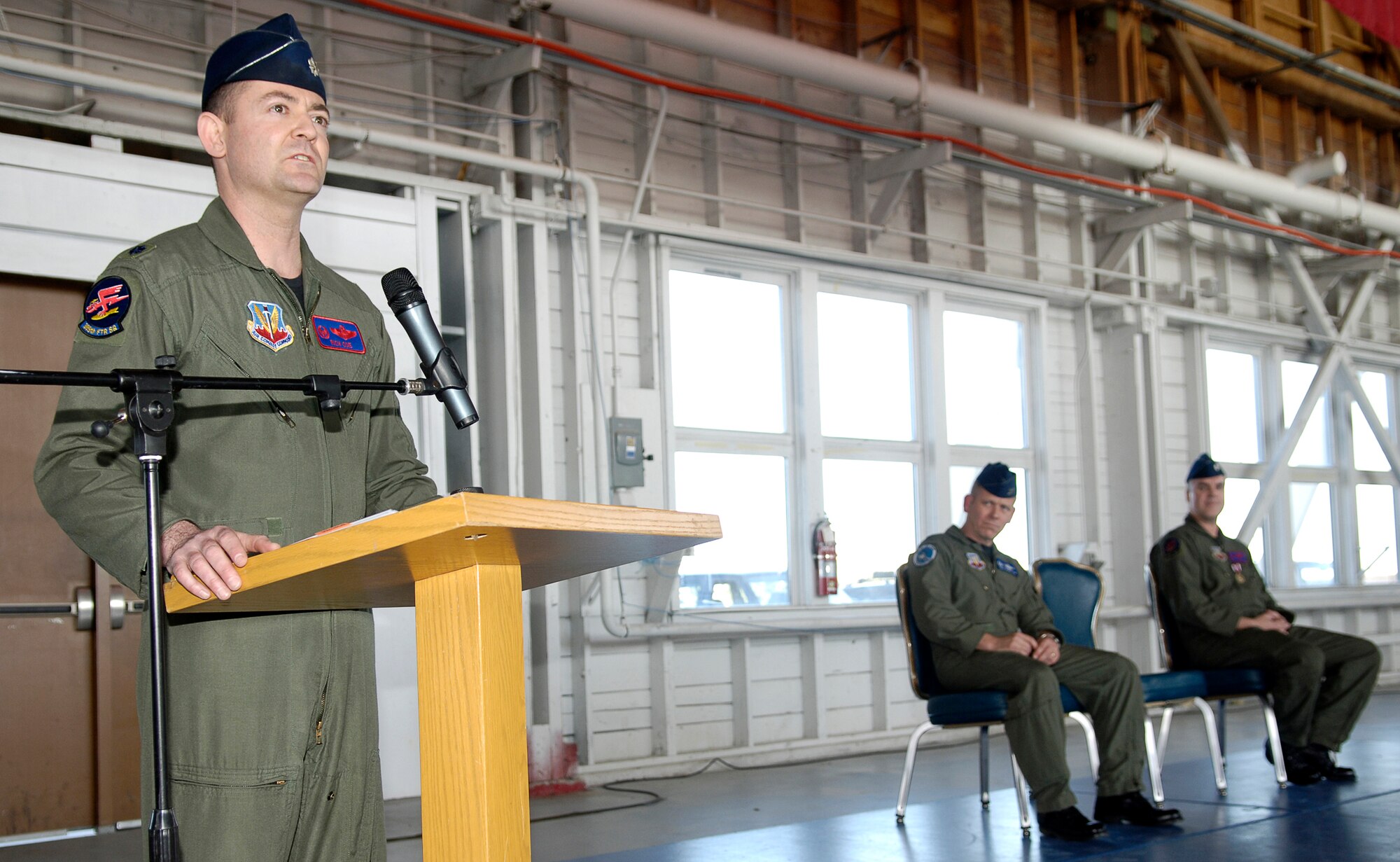 MOUNTAIN HOME AIR FORCE BASE, Idaho -- From left, Lt. Col. Richard Coe speaks to Airmen of the 389th Fighter Squadron while 366th Operations Group Commander Col. John McMullen and Lt. Col. Phillip Hoover look on during a change of command ceremony here March 23.  Colonel Coe took command of the Thunderbolts from Colonel Hoover during the ceremony. The event heralded a new era for the squadron, which continues to transition from the F-16CJ to the F-15E Strike Eagle as part of the Air Force's move to create a core F-15 wing here. Air Force photo by Airman 1st Class Ryan Crane