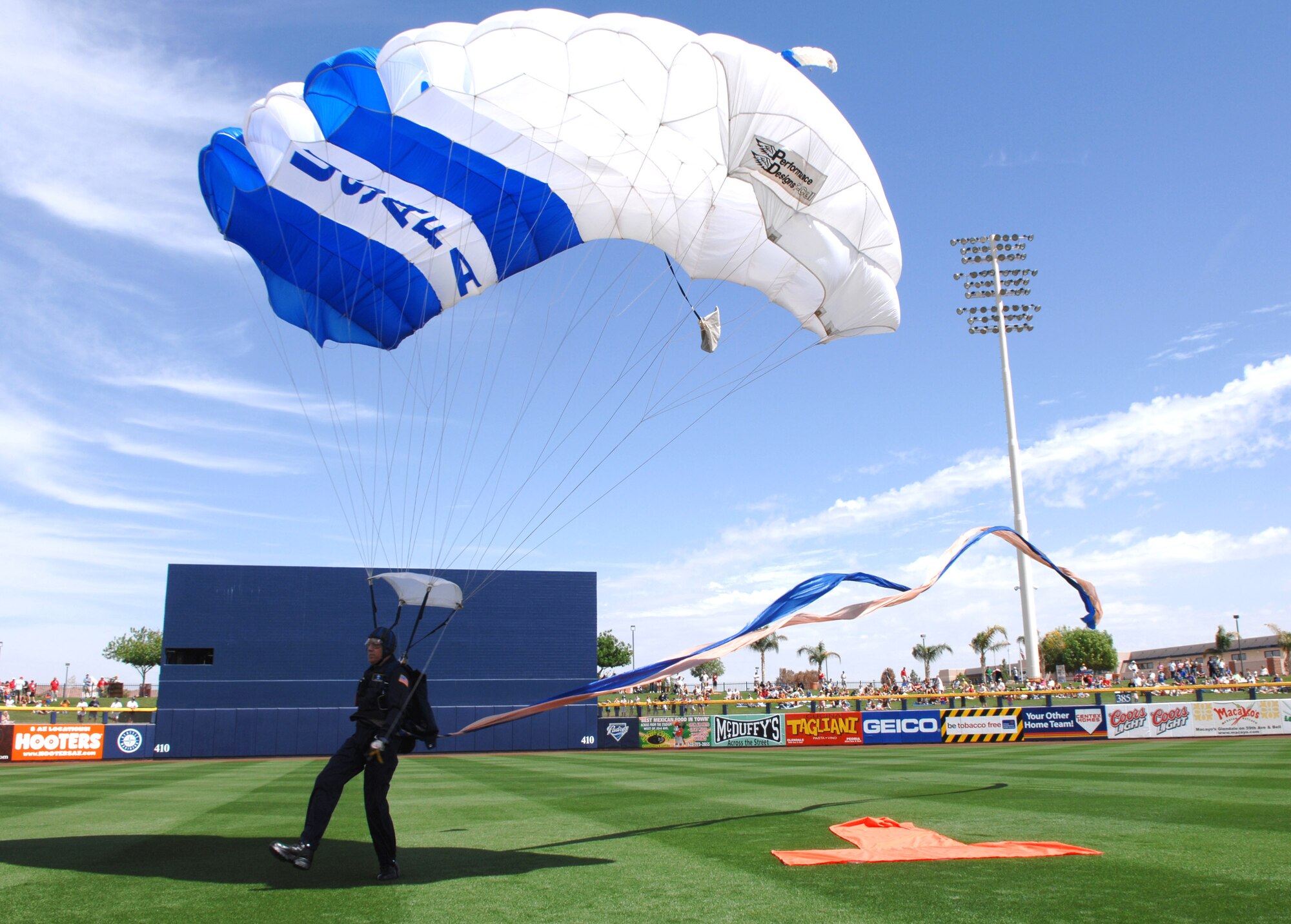 The Wings of Blue parachute demonstration team jump in with the game ball as the city of Peoria, Ariz., and the Peoria Sports Complex play host to Air Force Week during a 2007 spring training baseball game between the San Diego Padres and the Milwaukee Brewers March 21. (U.S. Air Force photo/Staff Sgt. Brian Ferguson)